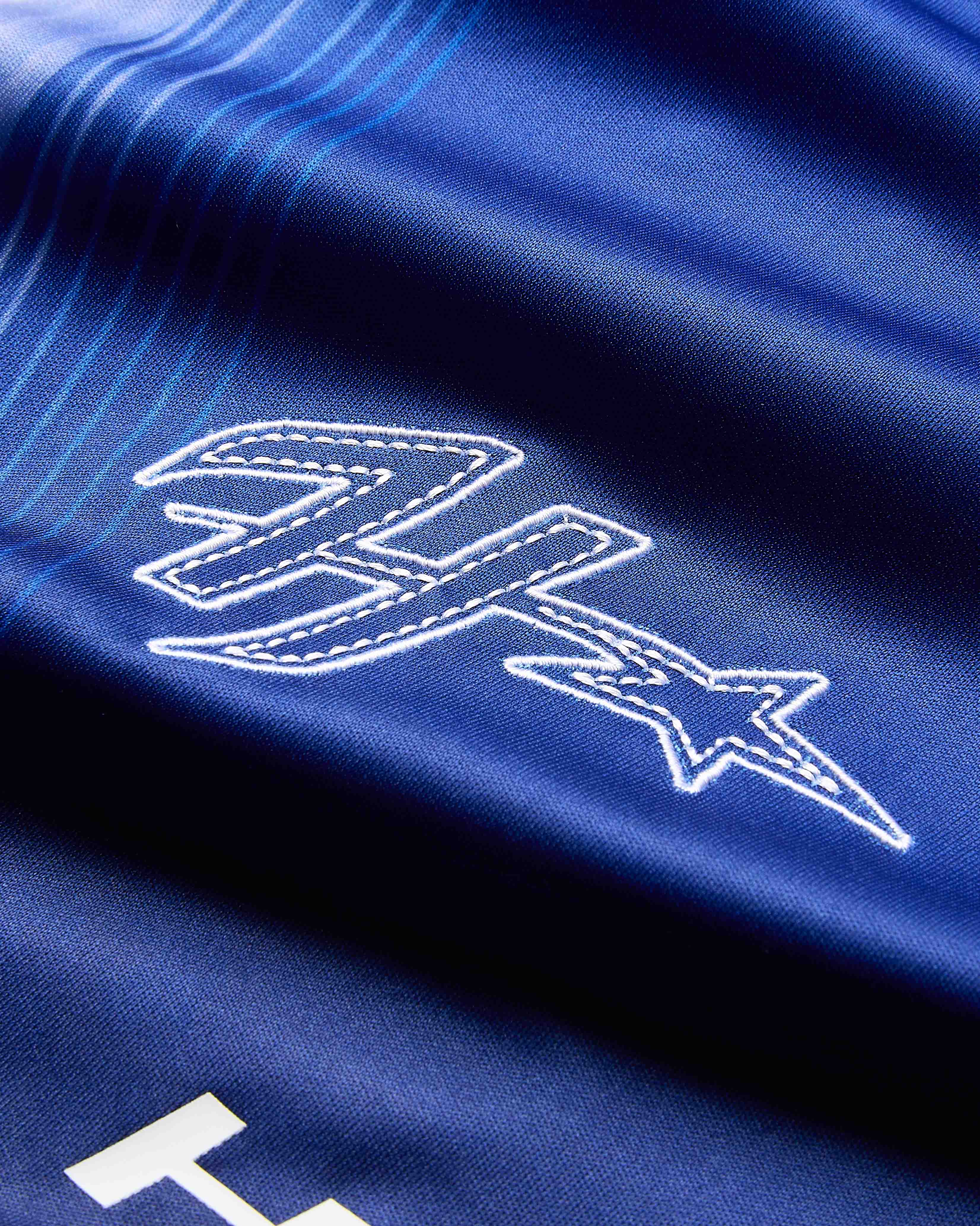Close-up of a blue fabric with white embroidered logo