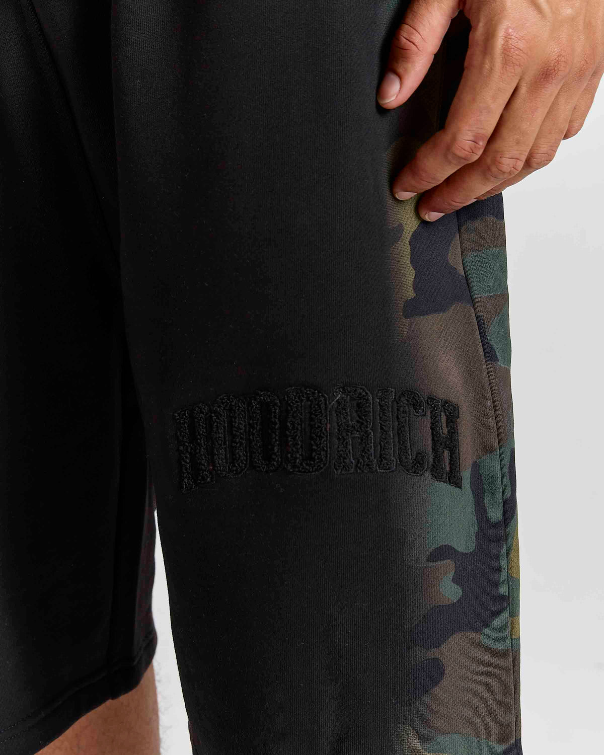 Displays a model wearing the Black Camo 'Hoodrich' branded men's Shade Matching Shorts Set