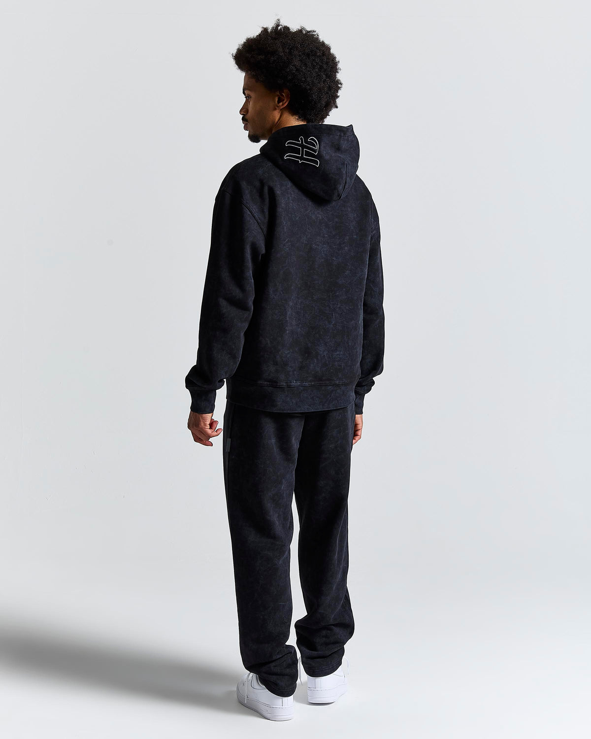 Displays a model wearing the Black 'Hoodrich' branded men's Nocturn Full Tracksuit