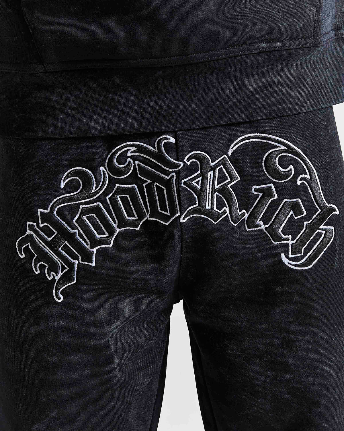 Displays a model wearing the Black 'Hoodrich' branded men's Nocturn Full Tracksuit featuring the hoodrich branding