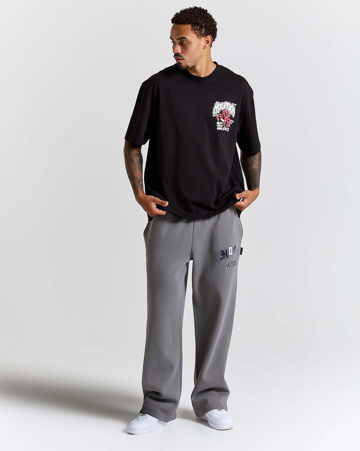 Displays a model wearing the Black 'Hoodrich' branded Fortune Oversized T-Shirt