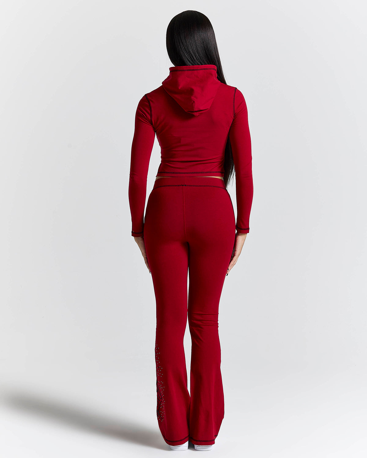 Displays a model wearing the Red 'Hoodrich' branded women's Gleam Full Tracksuit