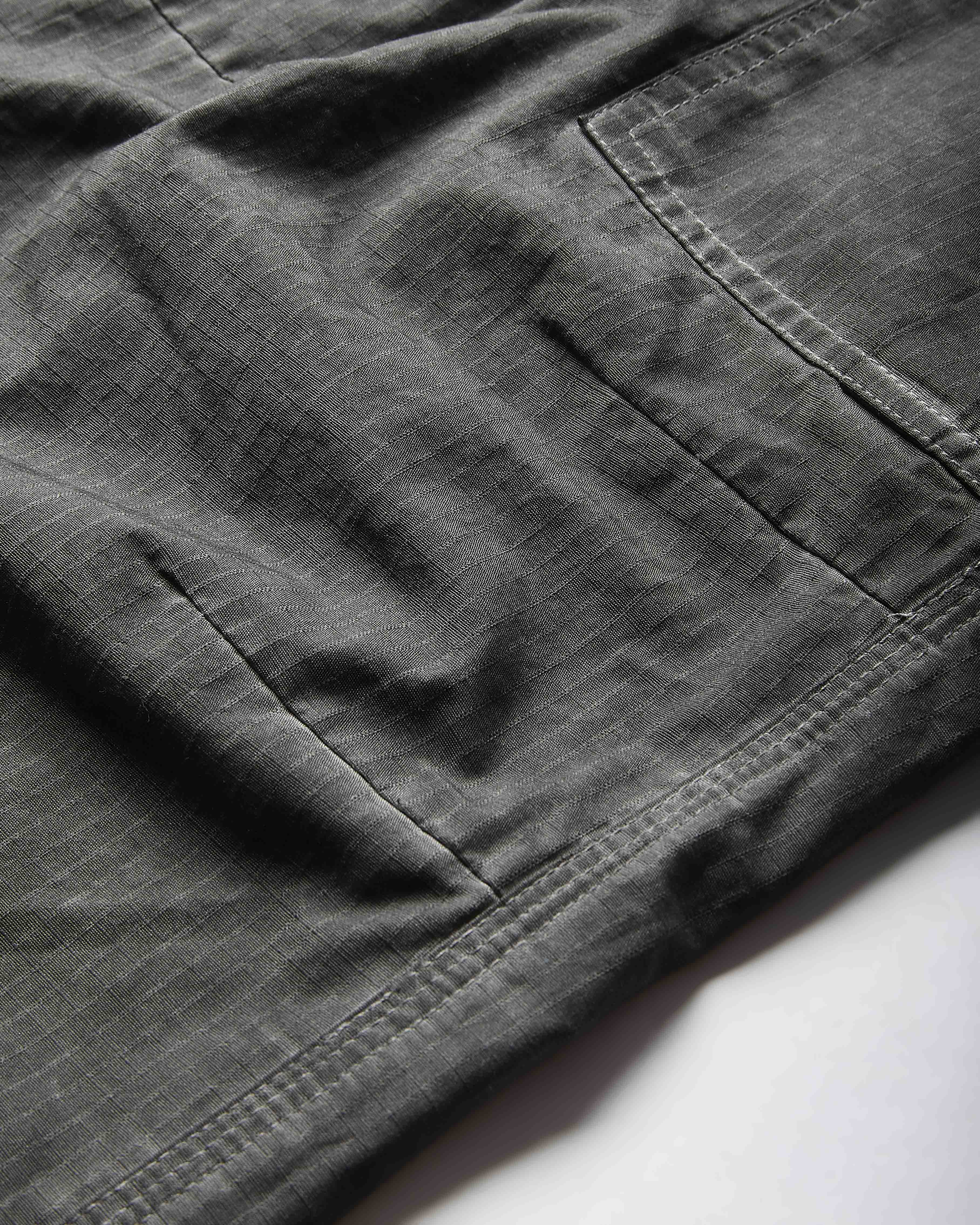 Close-up of dark gray pants on a white background