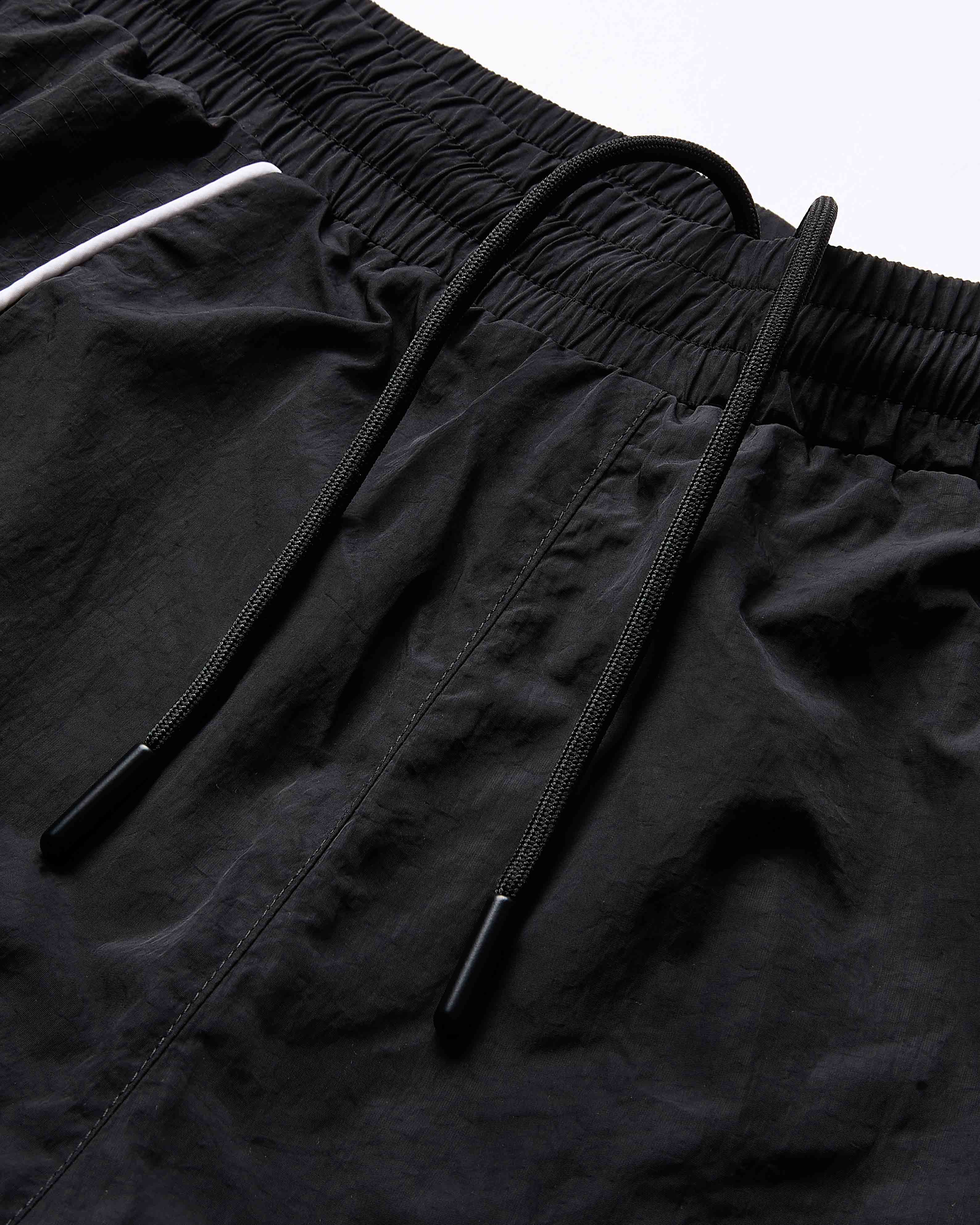 Close-up of black shorts with drawstring on a light gray background