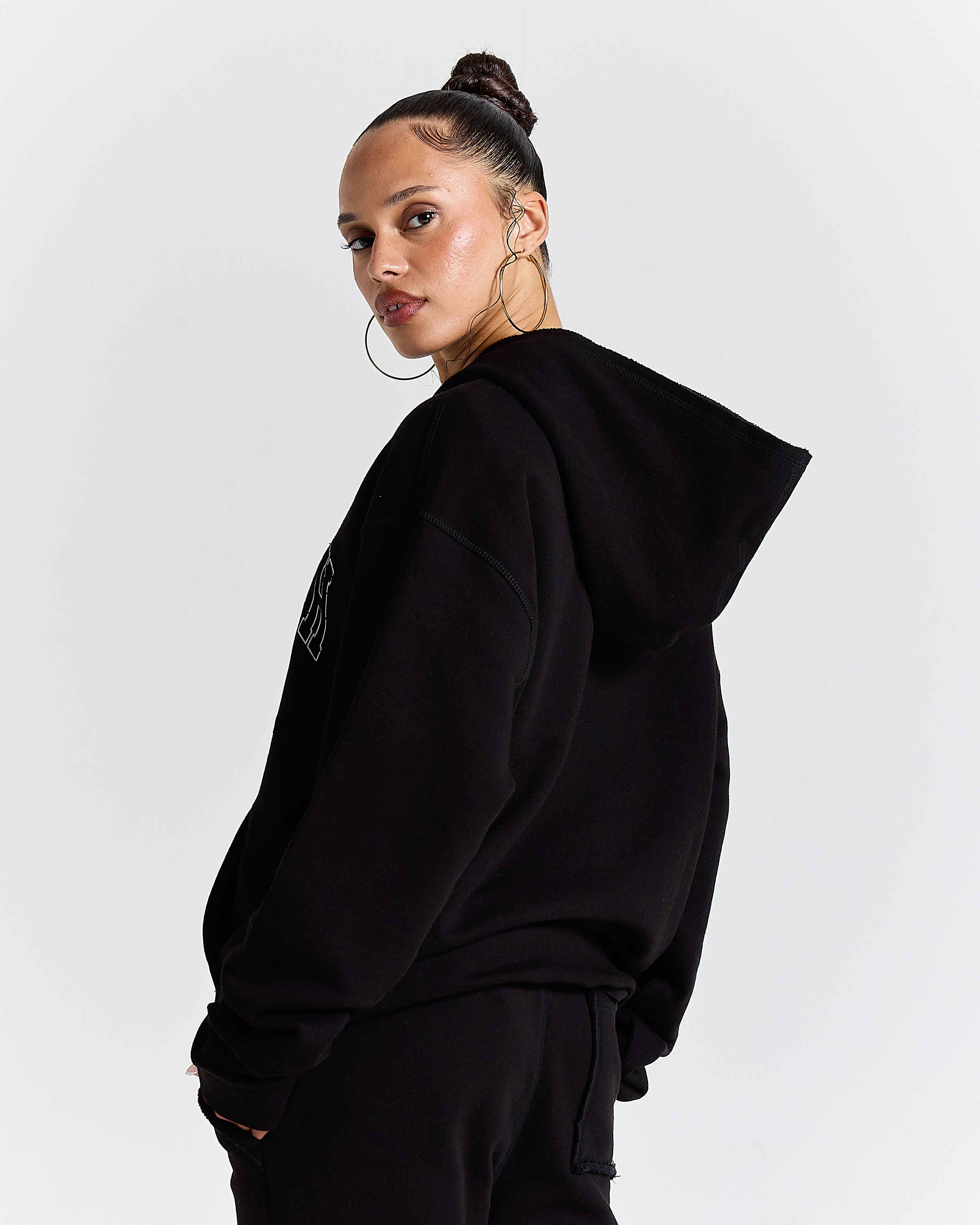 Person wearing a black hoodie on a plain background