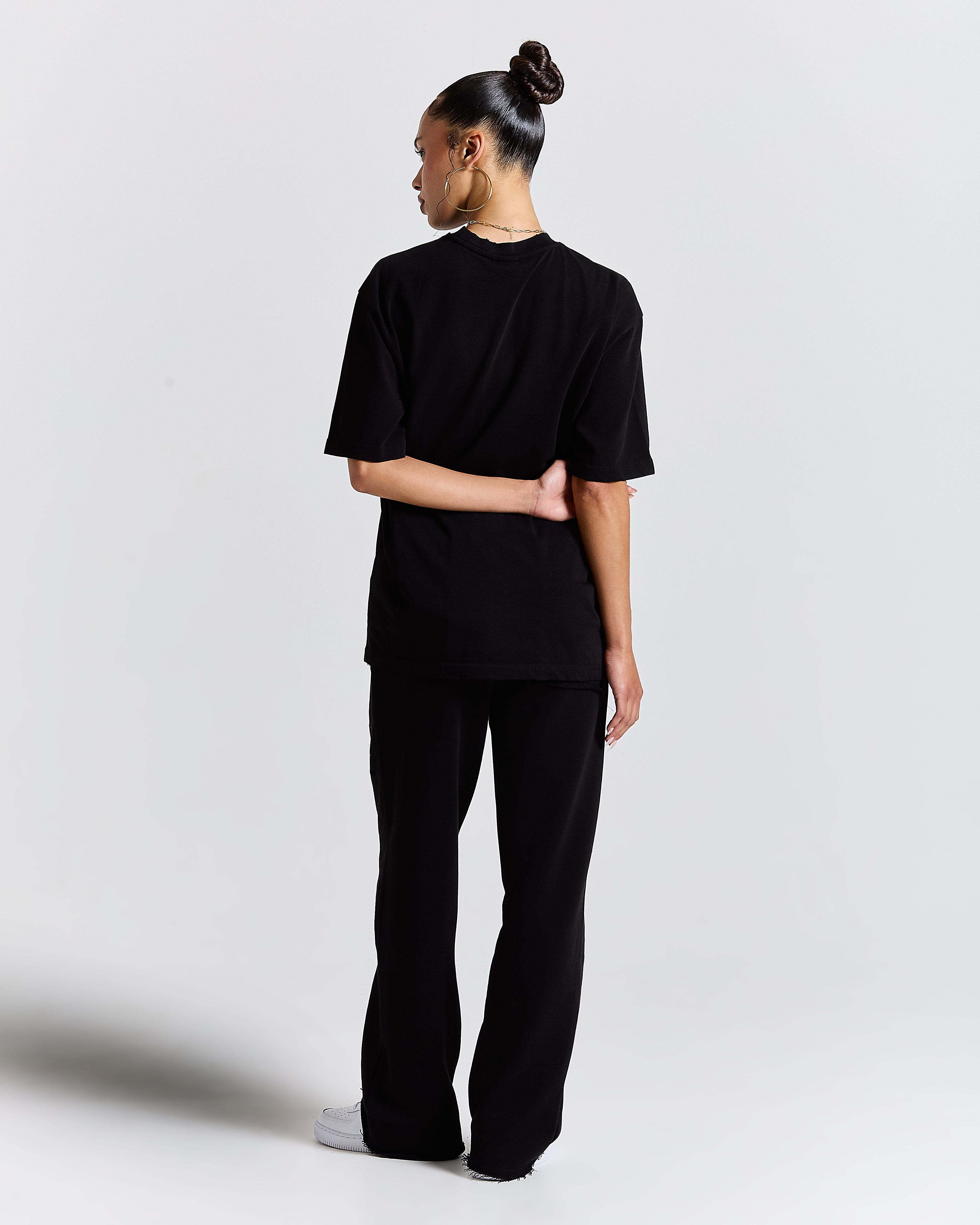 Person wearing a black outfit on a white background
