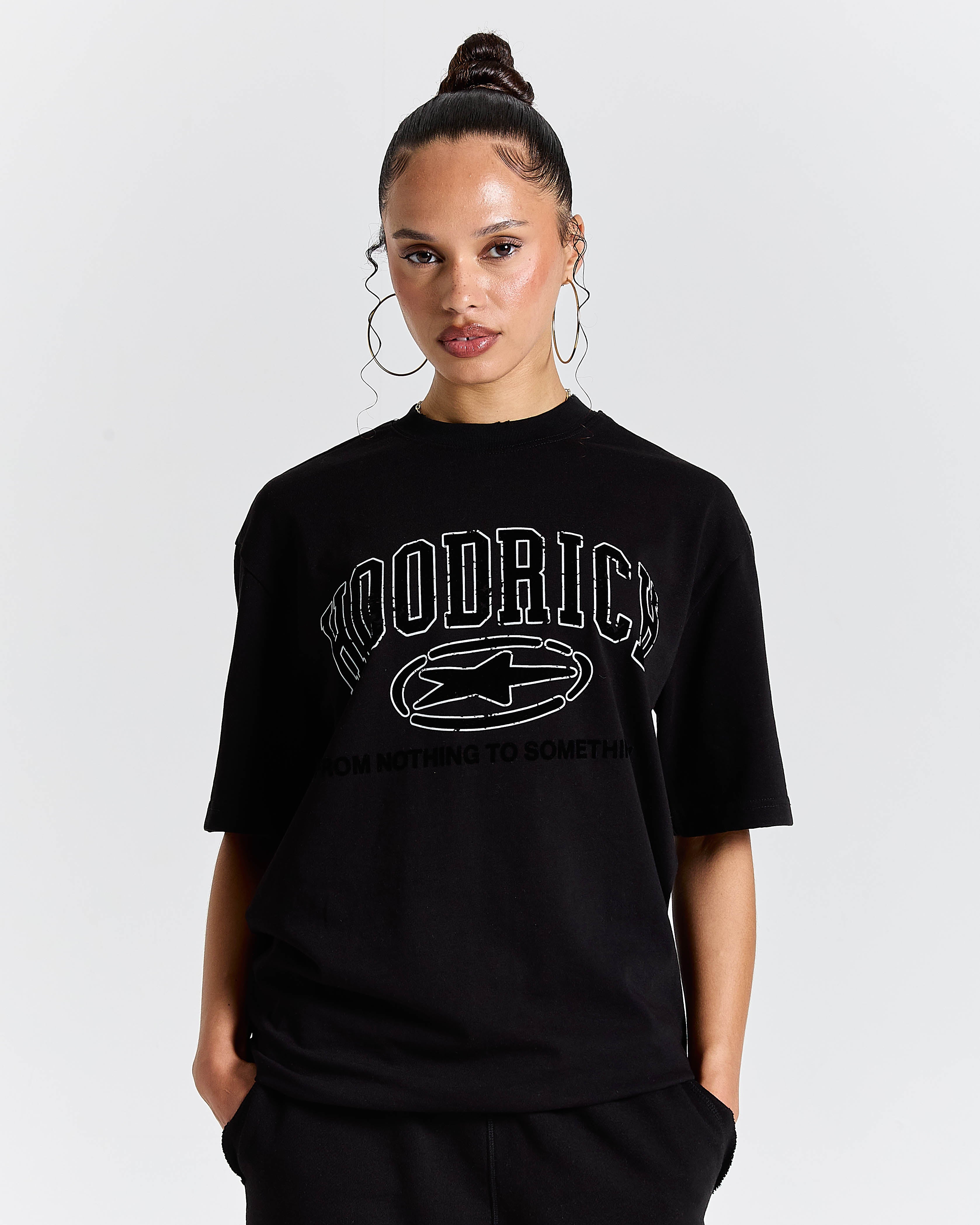 Person wearing a black t-shirt with 'Hoodrich' logo on a plain background