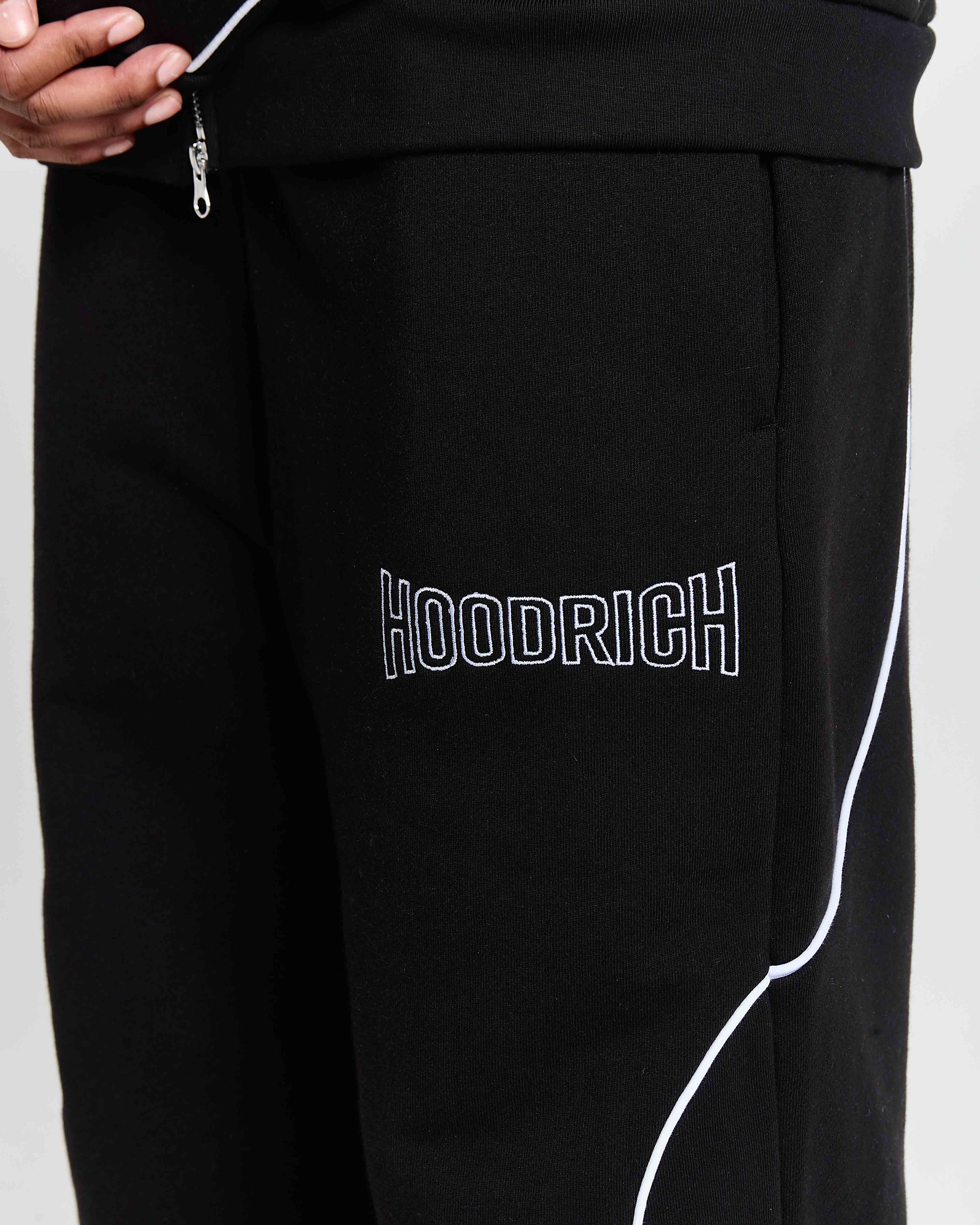 Black pants with 'HOODRICH' branding on a white background