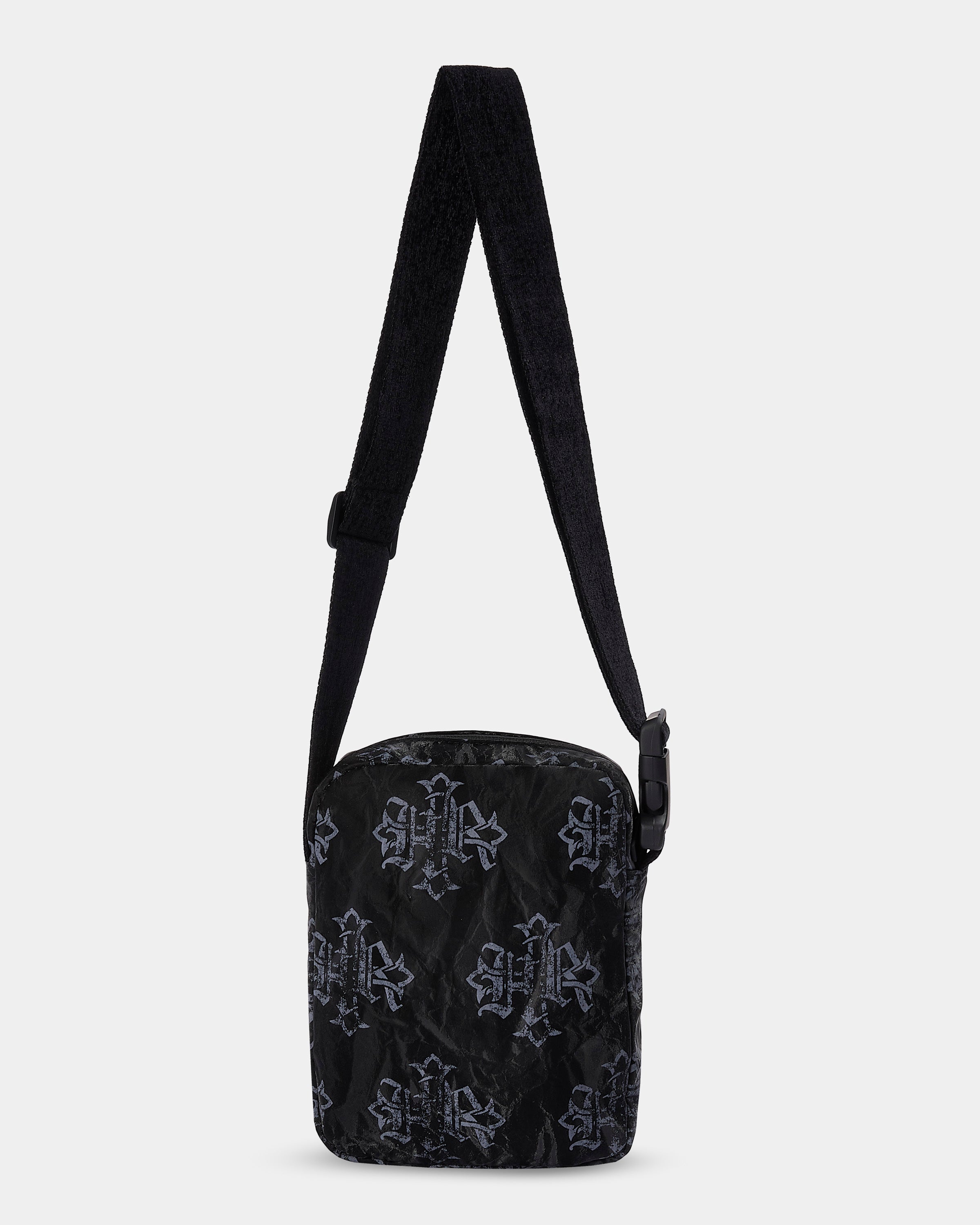 Black patterned crossbody bag on a light gray background