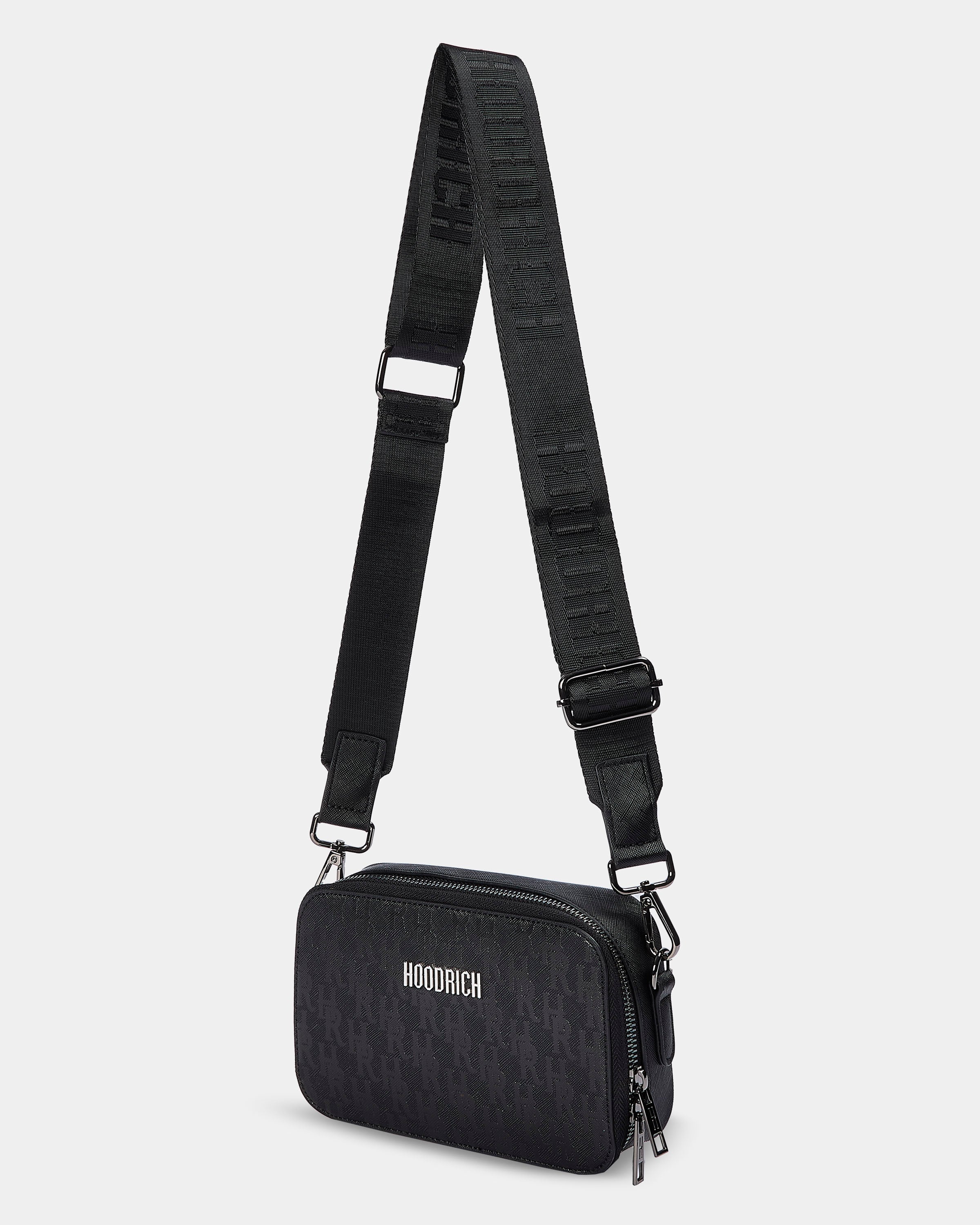 Black crossbody bag with a strap on a light gray background