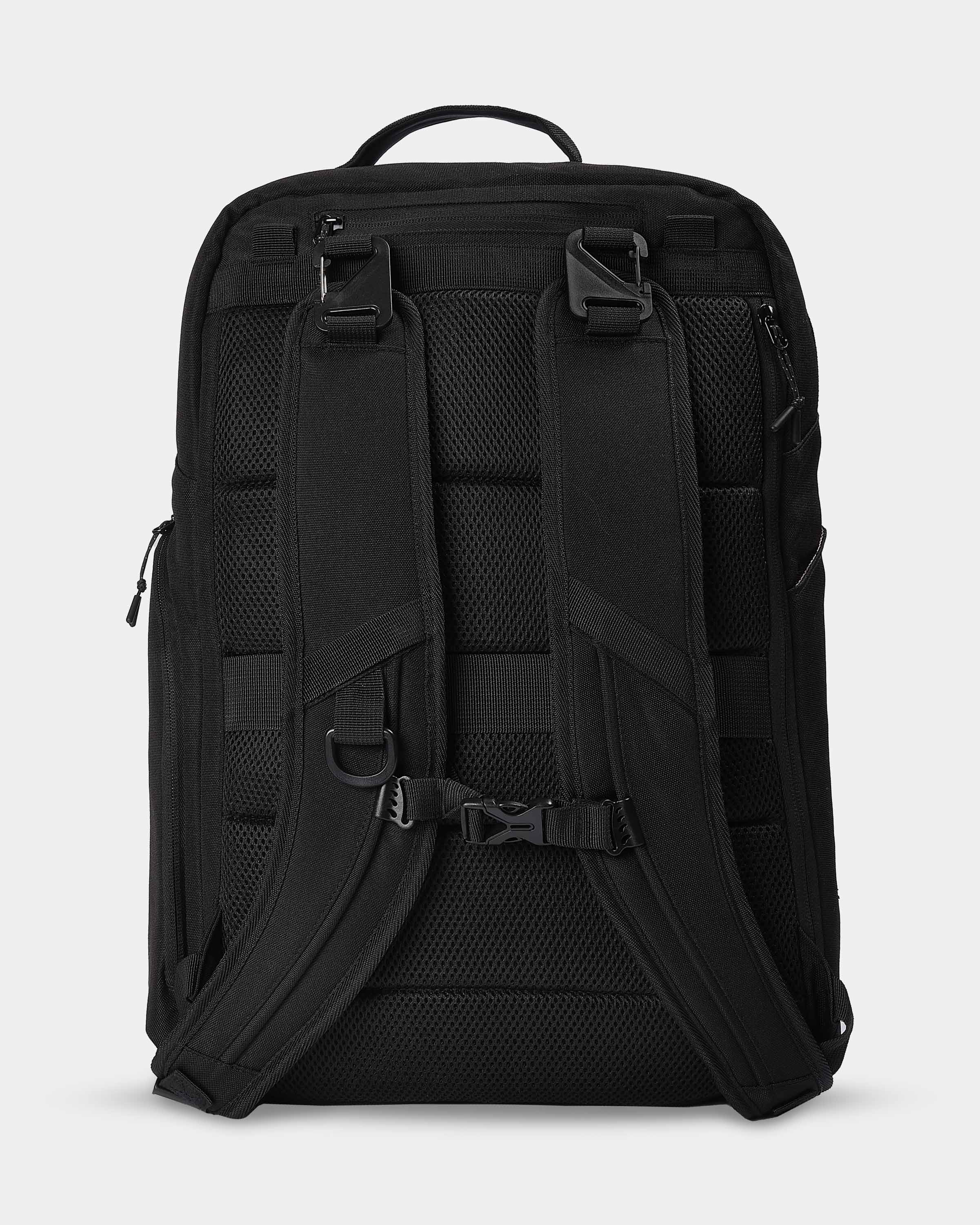 Black backpack with multiple straps and compartments on a light gray background