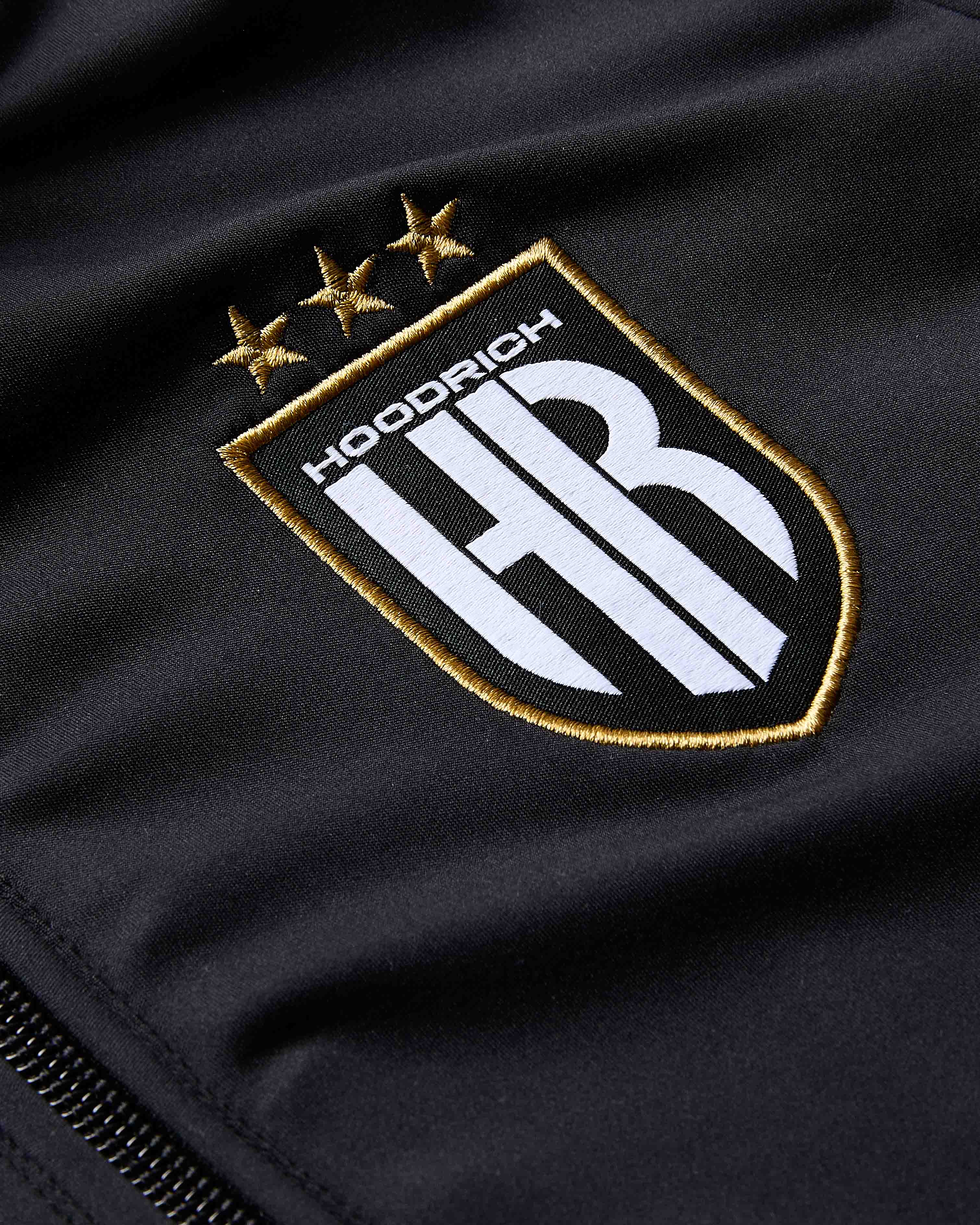 Embroidered logo on a black fabric background