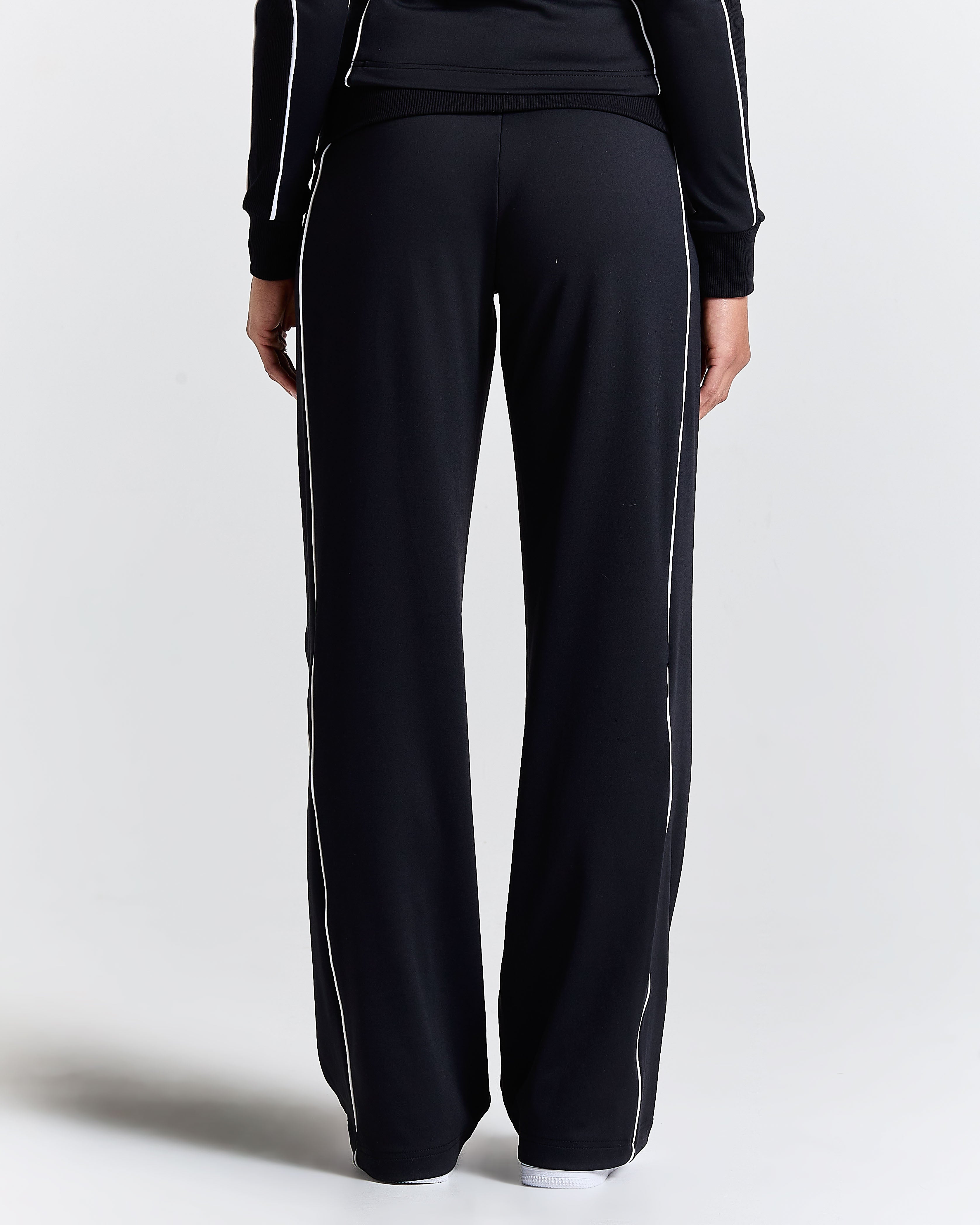 Displays a model wearing the Black 'Hoodrich' branded women's Glide Football Full Tracksuit