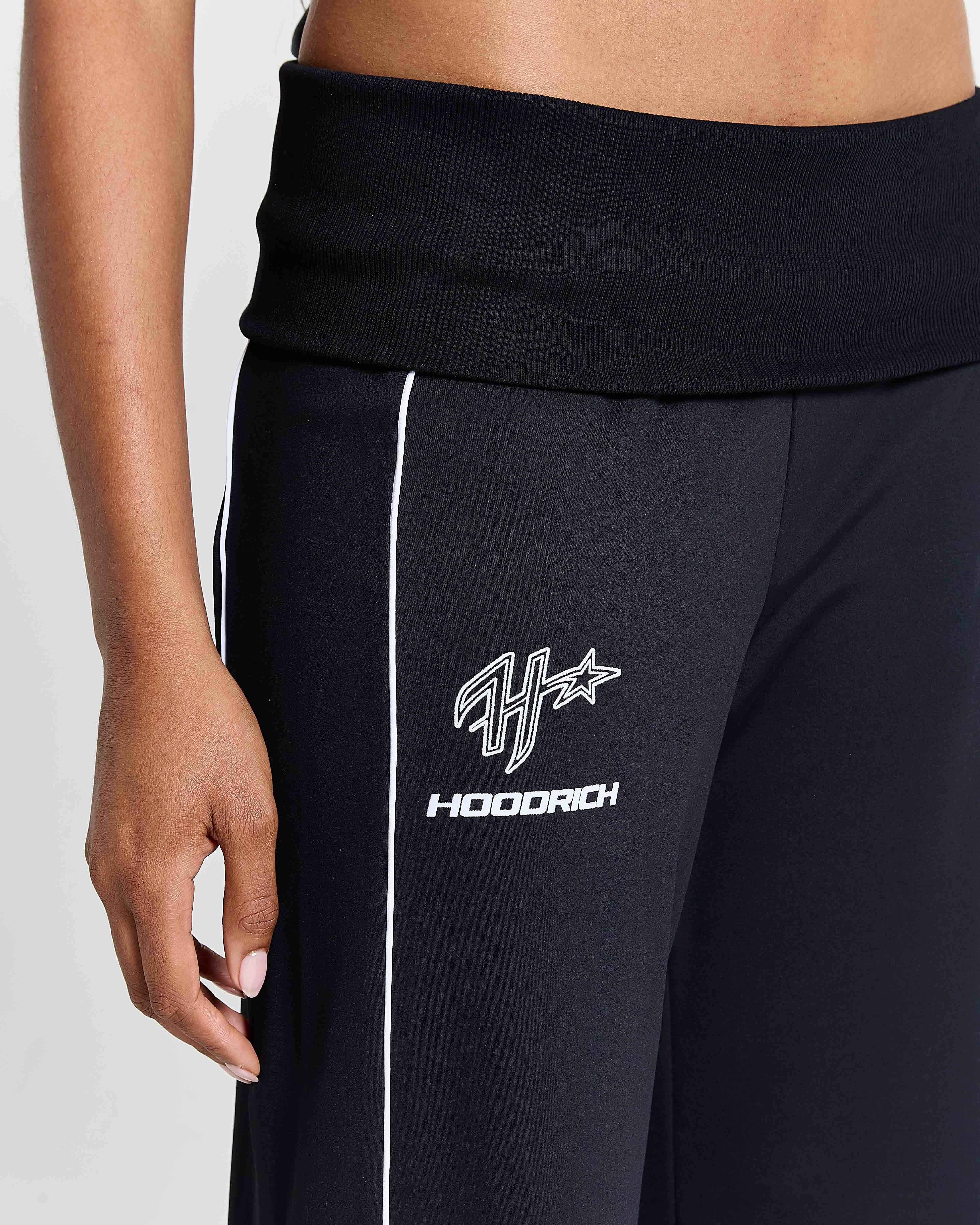 Black tracksuit pants with a logo on a white background