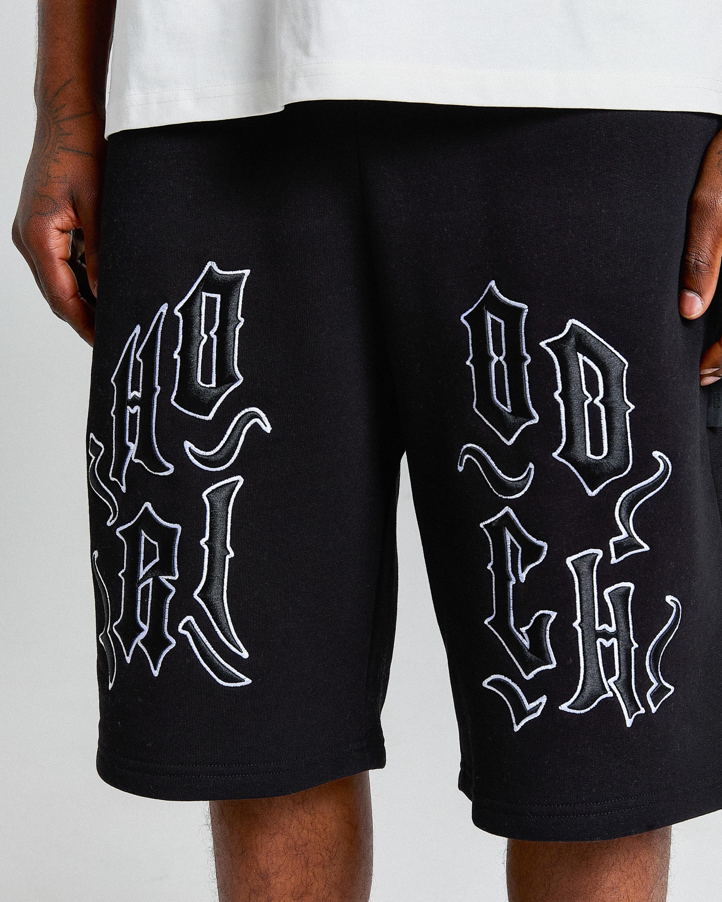 Black shorts with white text design on a plain background