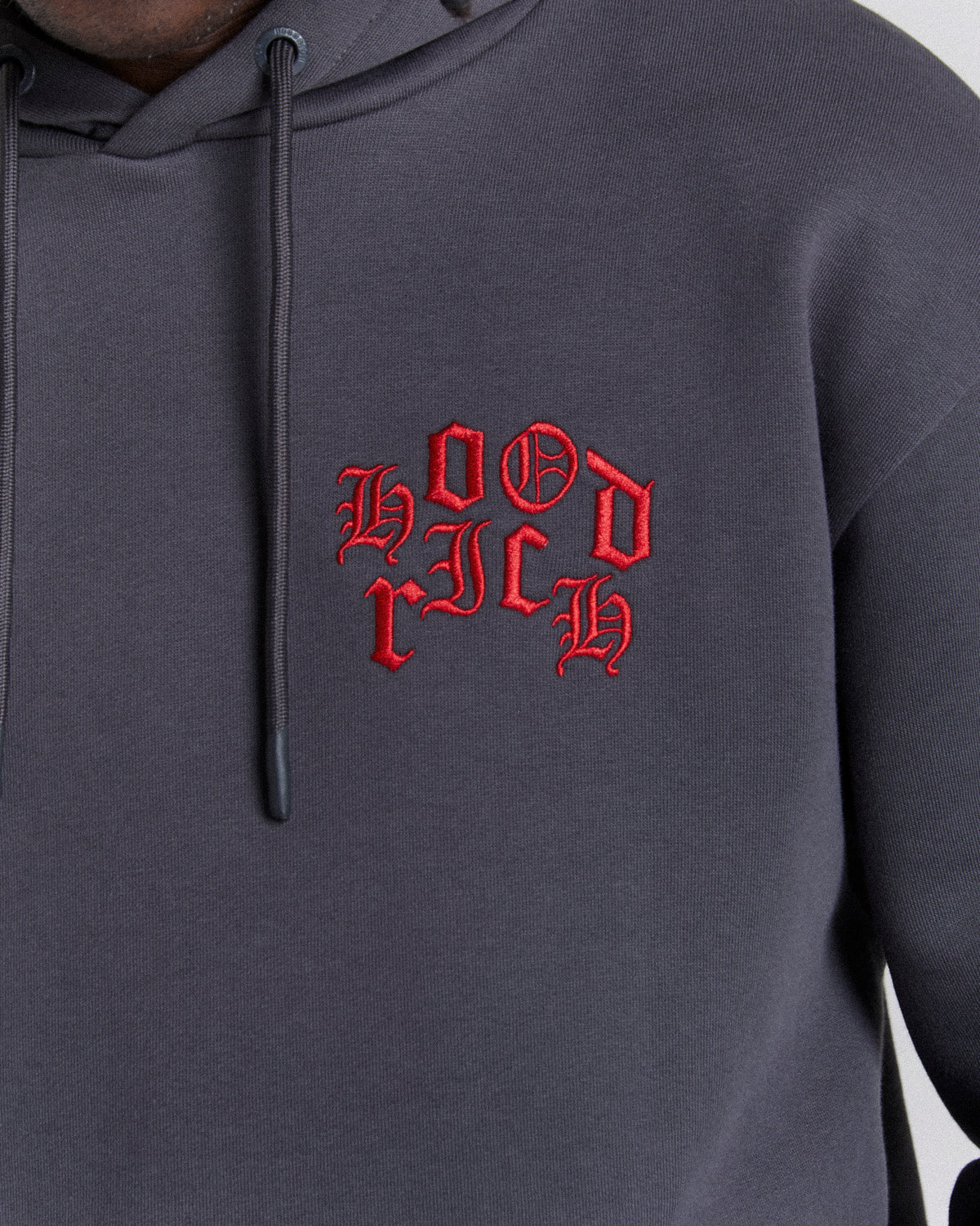 Displays a model wearing the Grey 'Hoodrich' branded men's Crown Full Tracksuit featuring the branding details