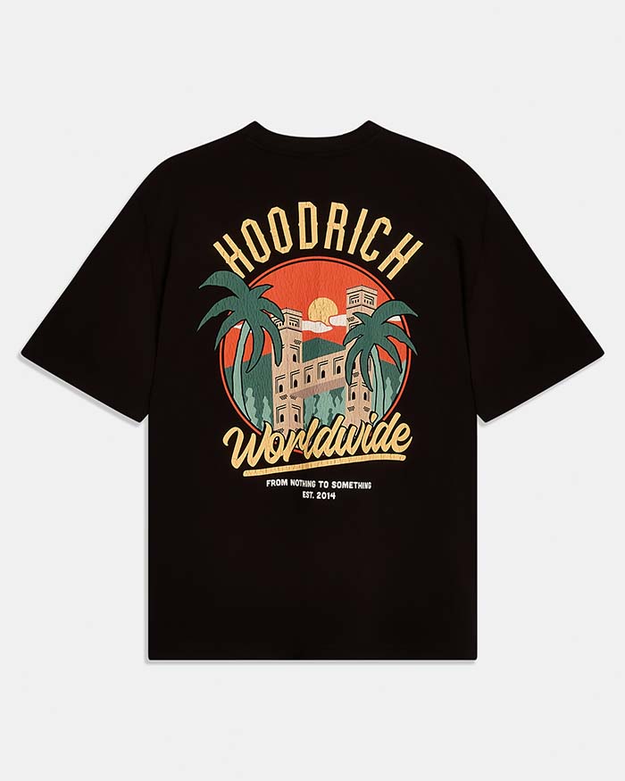 A black short-sleeve t-shirt with a large retro-style graphic on the front. The graphic features the text 'HOODRICH' in arched yellow letters above a circular illustration of a building, palm trees, and a sunset, with 'Worldwide' written in yellow script below.