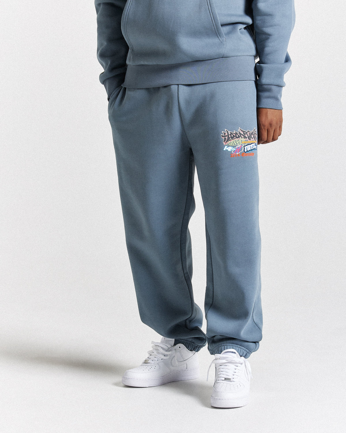 Displays a model wearing the Grey 'Hoodrich' branded men's Graff Rave Full Tracksuit