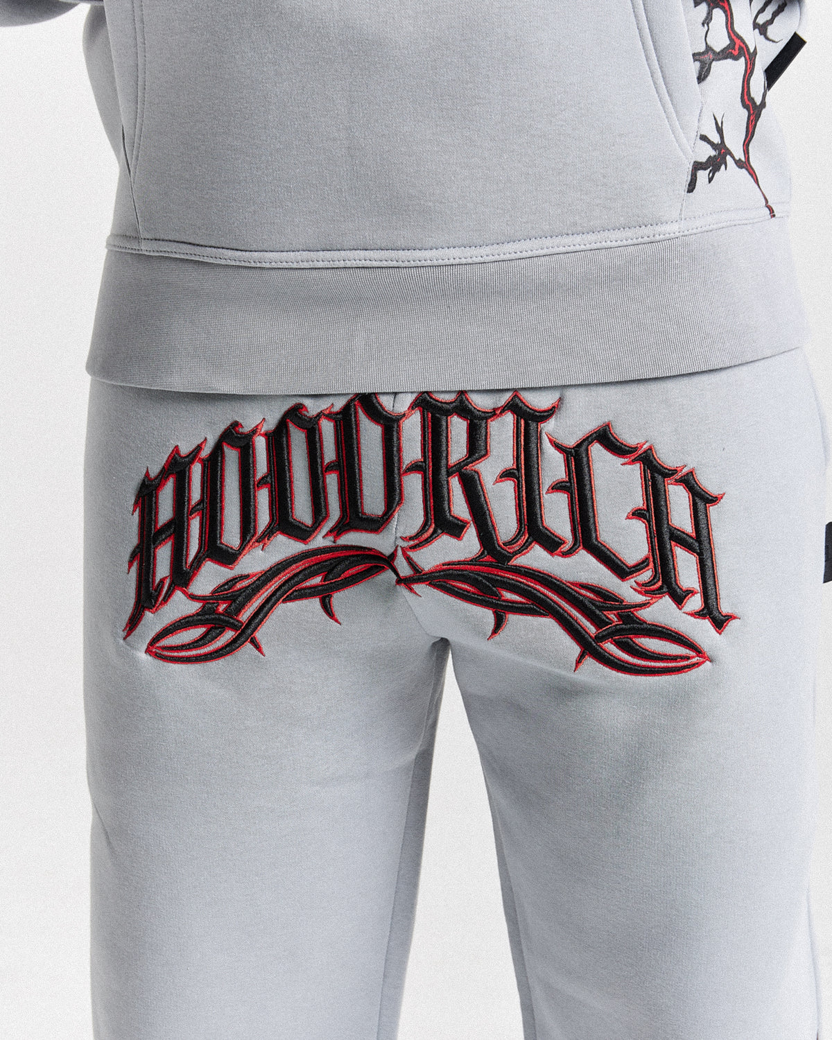Displays a model wearing the Grey 'Hoodrich' branded men's Dark Full Tracksuit featuring the hoodrich branding