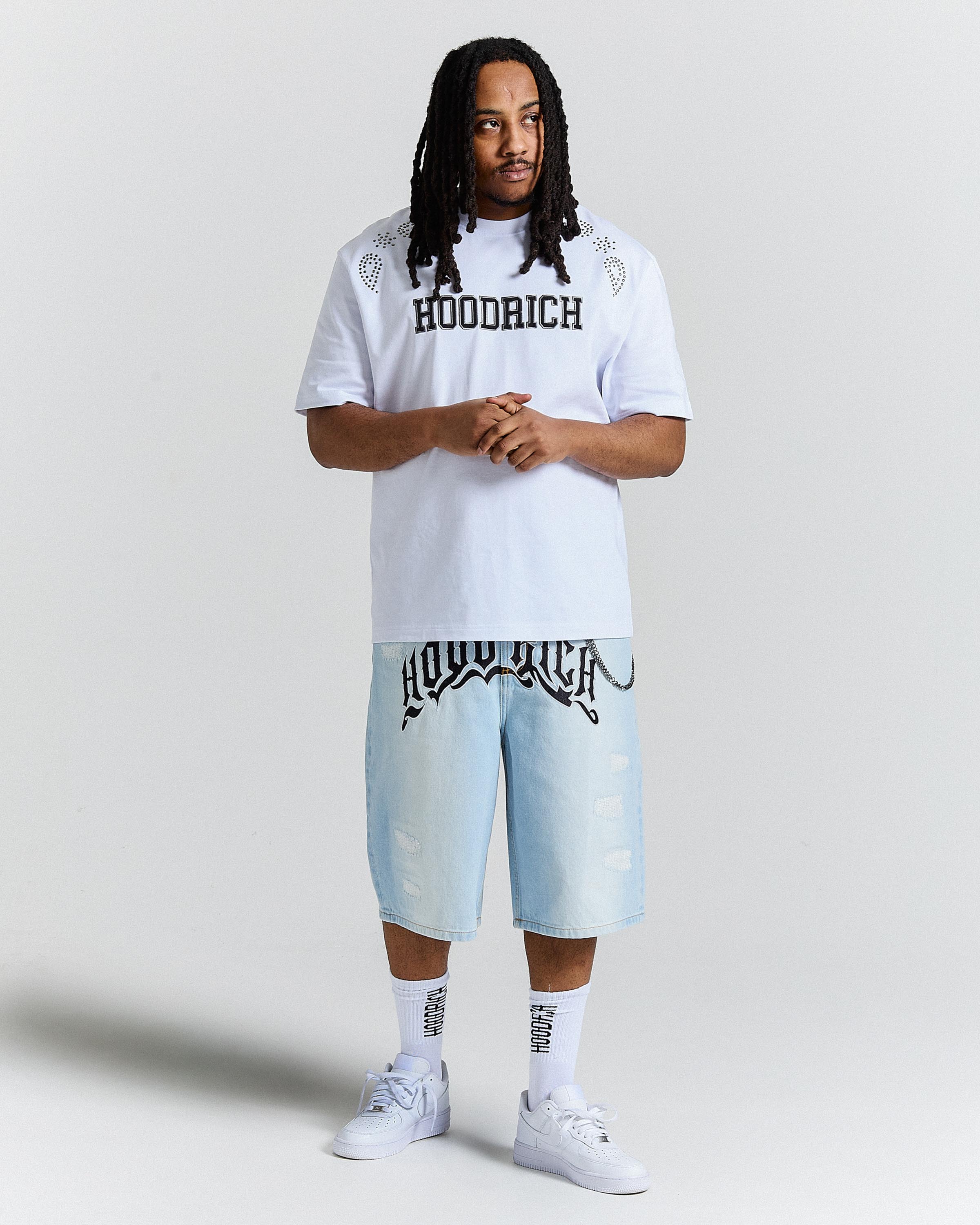 Person wearing a white t-shirt and light blue shorts with 'Hoodrich' branding on a plain background
