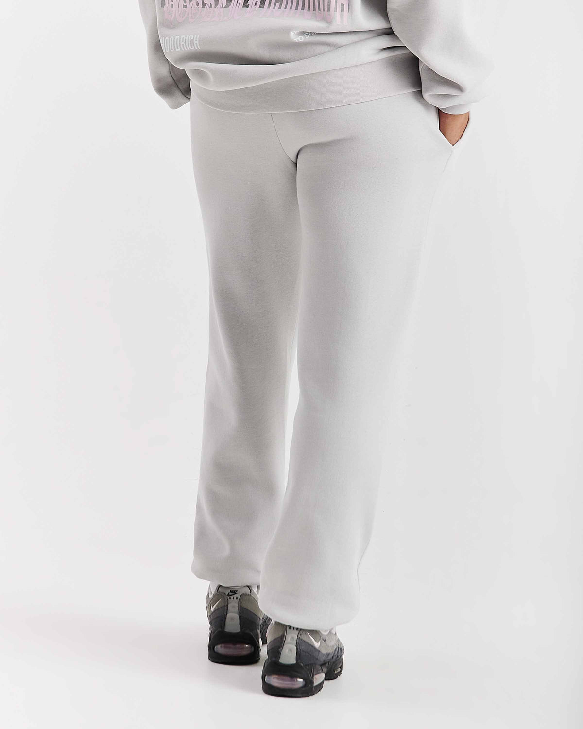 Displays a model wearing the Grey 'Hoodrich' branded women's Flex Full Tracksuit