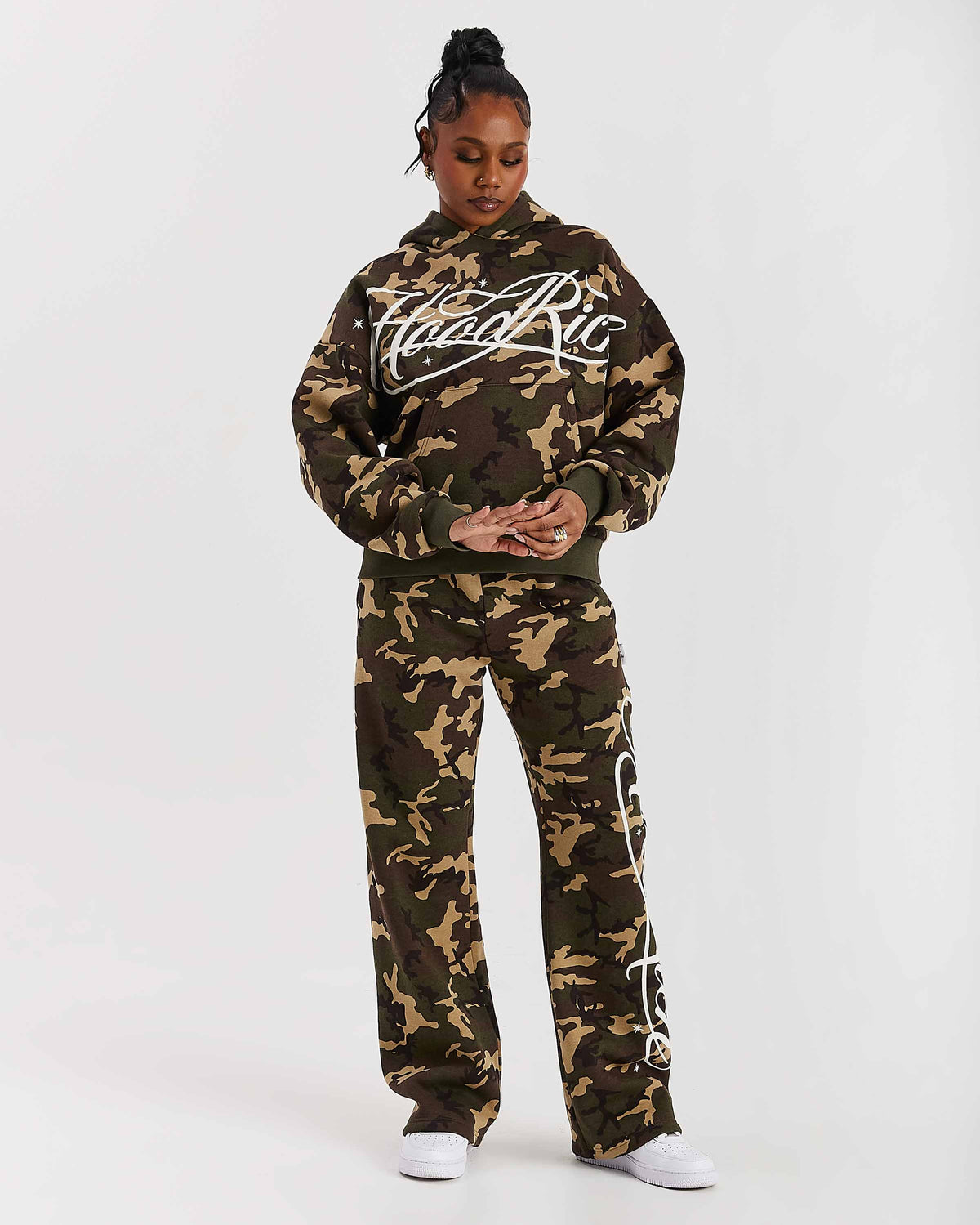 Displays a model wearing the Camo 'Hoodrich' branded women's Solace Full Tracksuit
