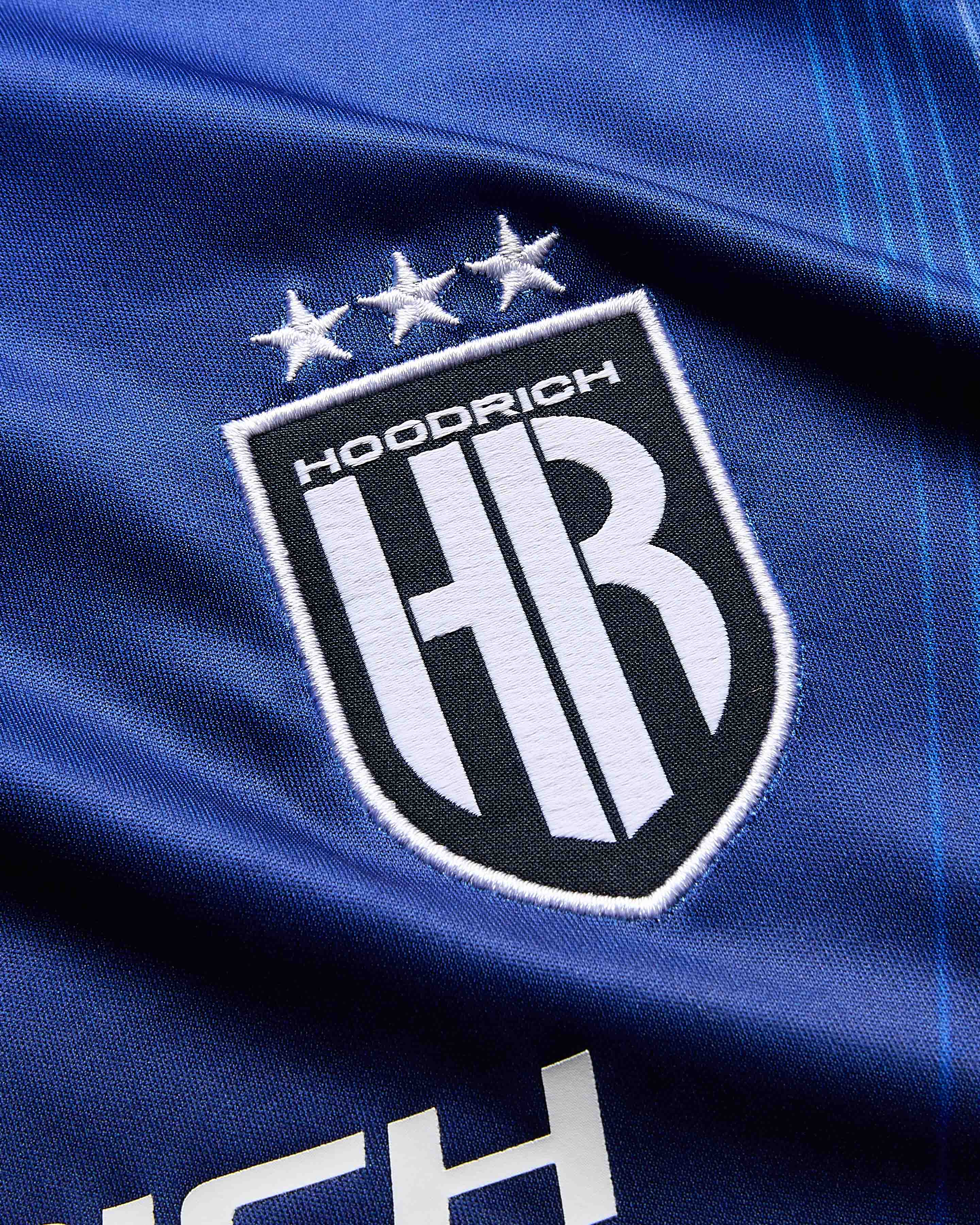 Close-up of a blue fabric with a logo featuring 'Hoodrich' and 'HR'.