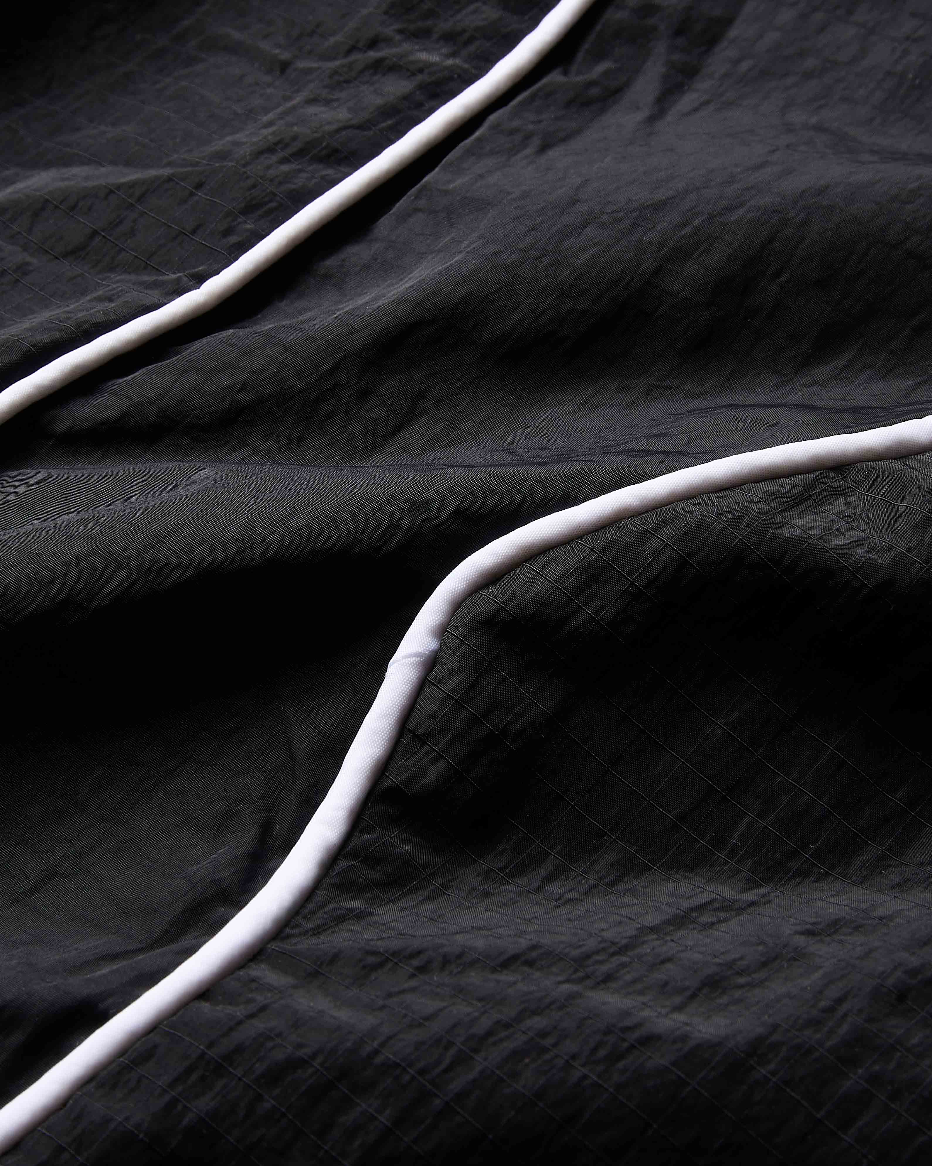 Close-up of black fabric with white cables on a dark background