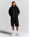 Displays a model wearing the Black Camo 'Hoodrich' branded men's Shade Matching Shorts Set 