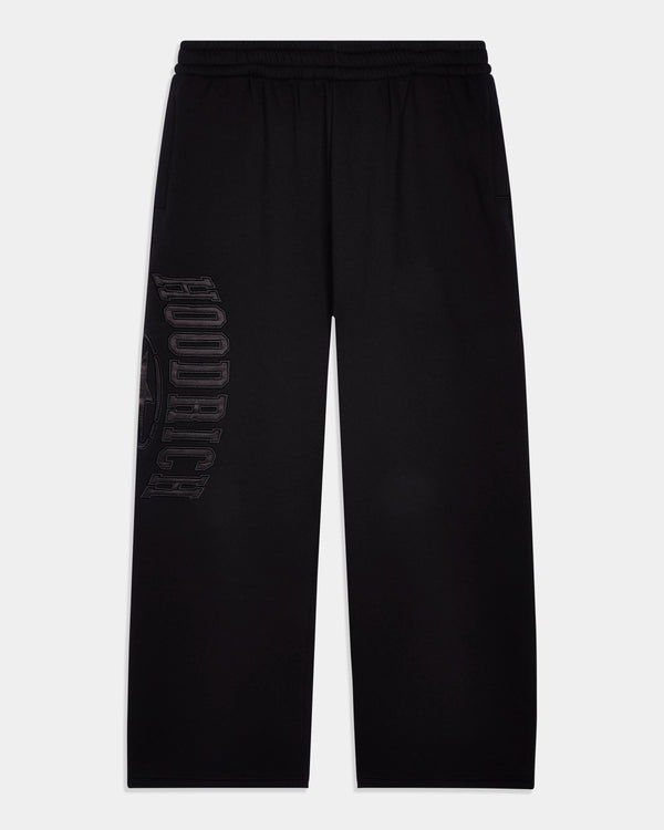 Black wide-leg sweatpants with a drawstring waistband and a tonal vertical 'HOODRICH' logo printed on the left leg, shown against a light gray background.
