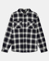 A long-sleeve button-up flannel shirt with a black and white plaid pattern, featuring two buttoned chest pockets, shown against a light gray background.