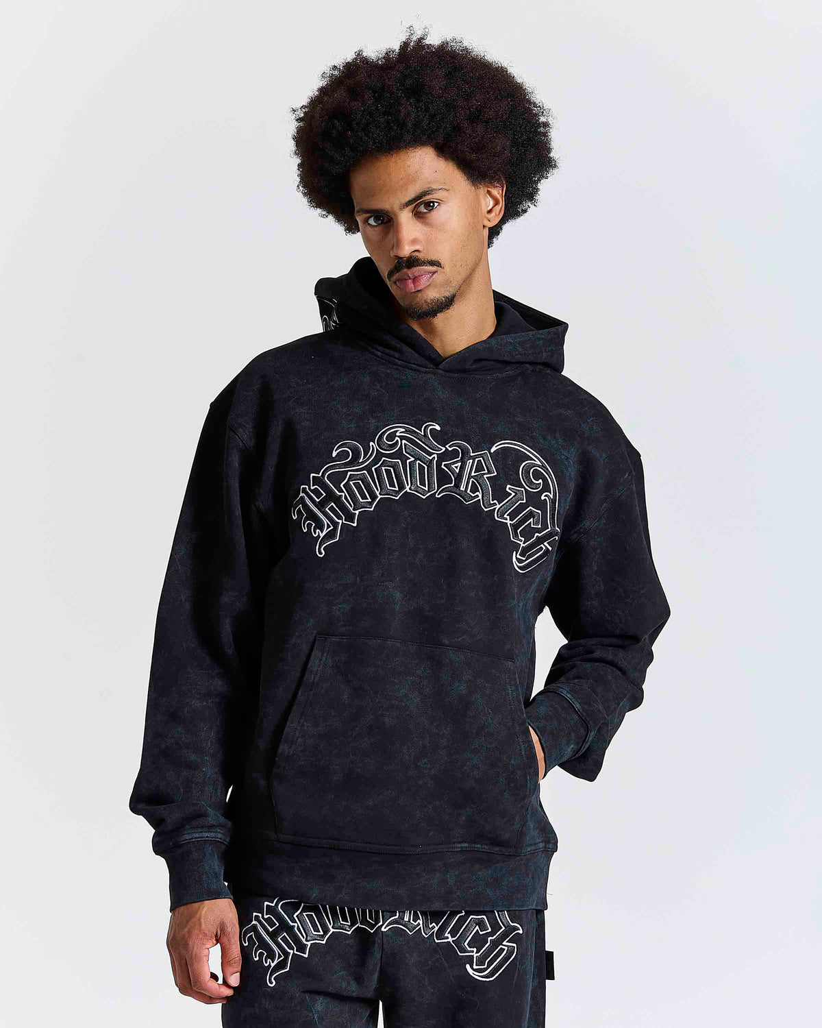 Displays a model wearing the Black 'Hoodrich' branded men's Nocturn Full Tracksuit 
