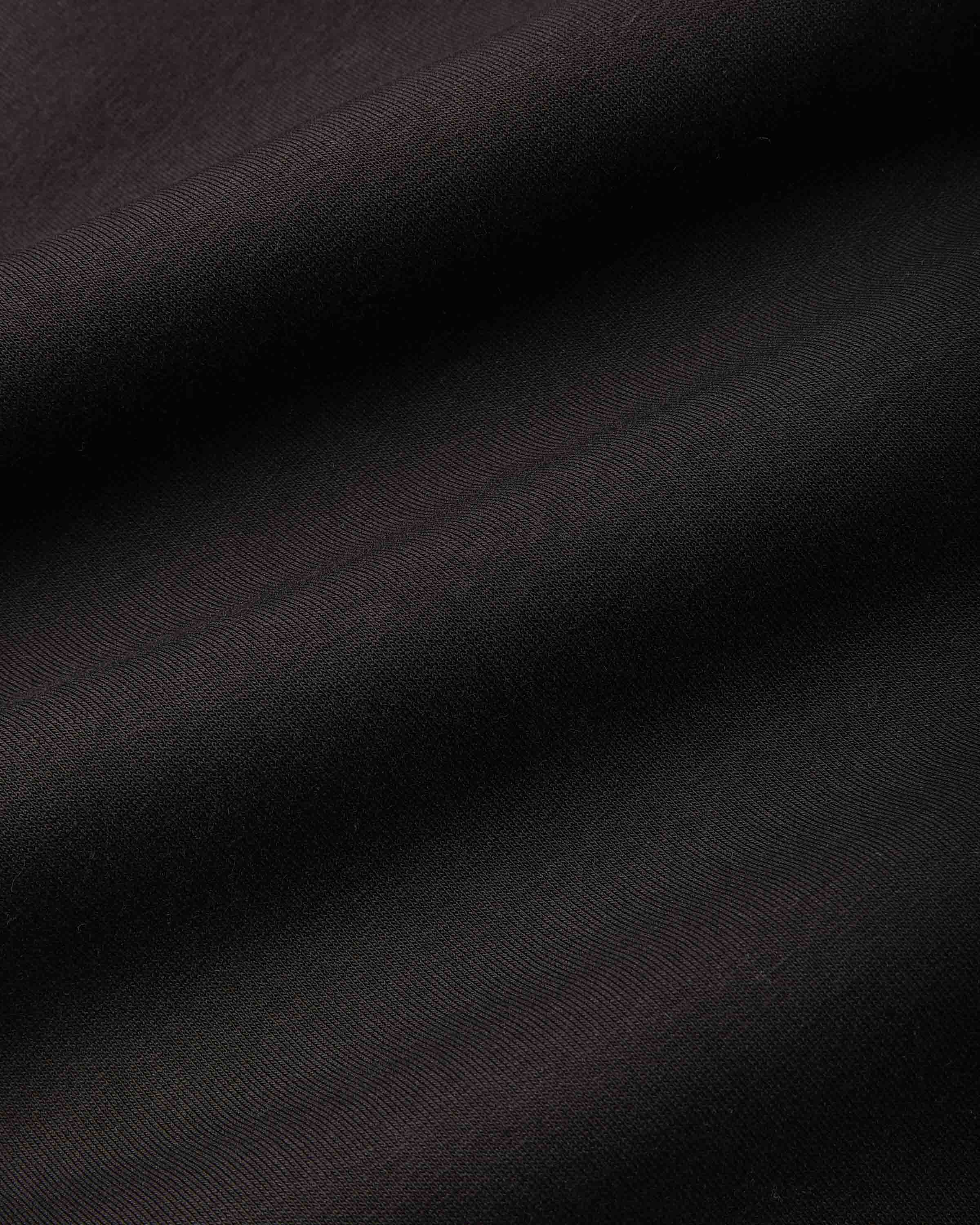 A close-up of dark fabric with a subtle sheen, showing diagonal folds and a fine woven texture in very dark brown or near-black tones.