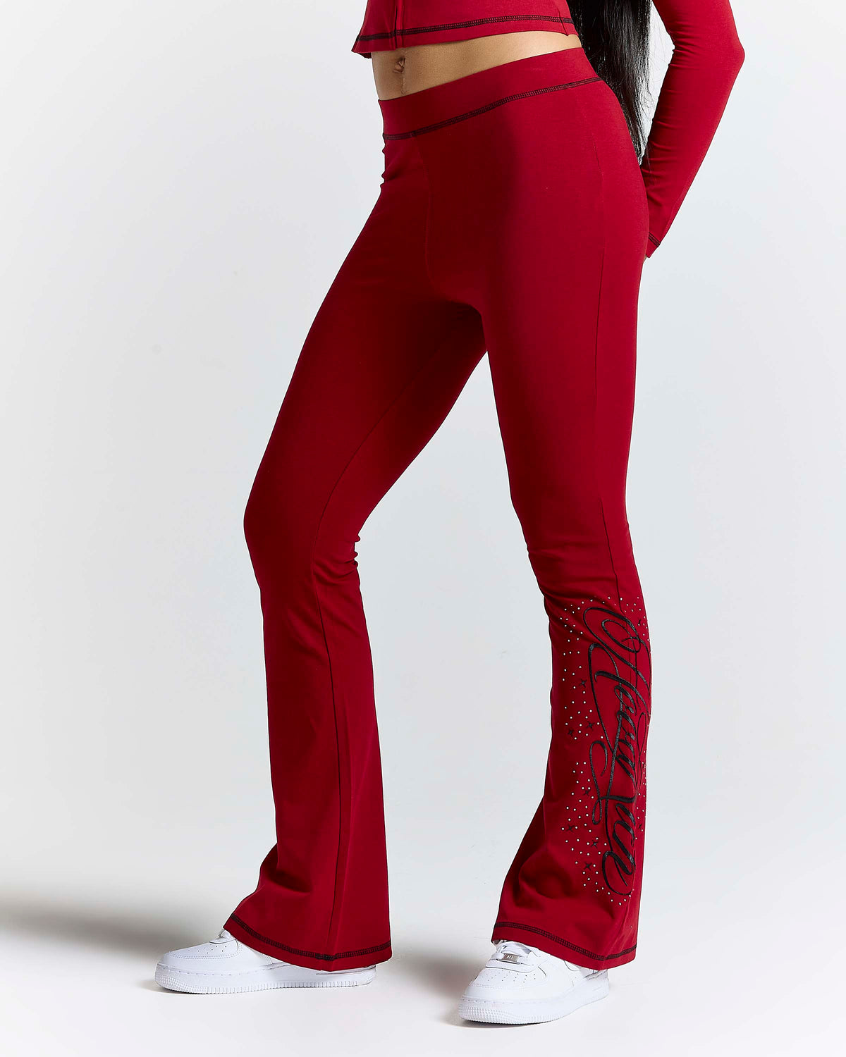 Displays a model wearing the Red 'Hoodrich' branded women's Gleam Full Tracksuit