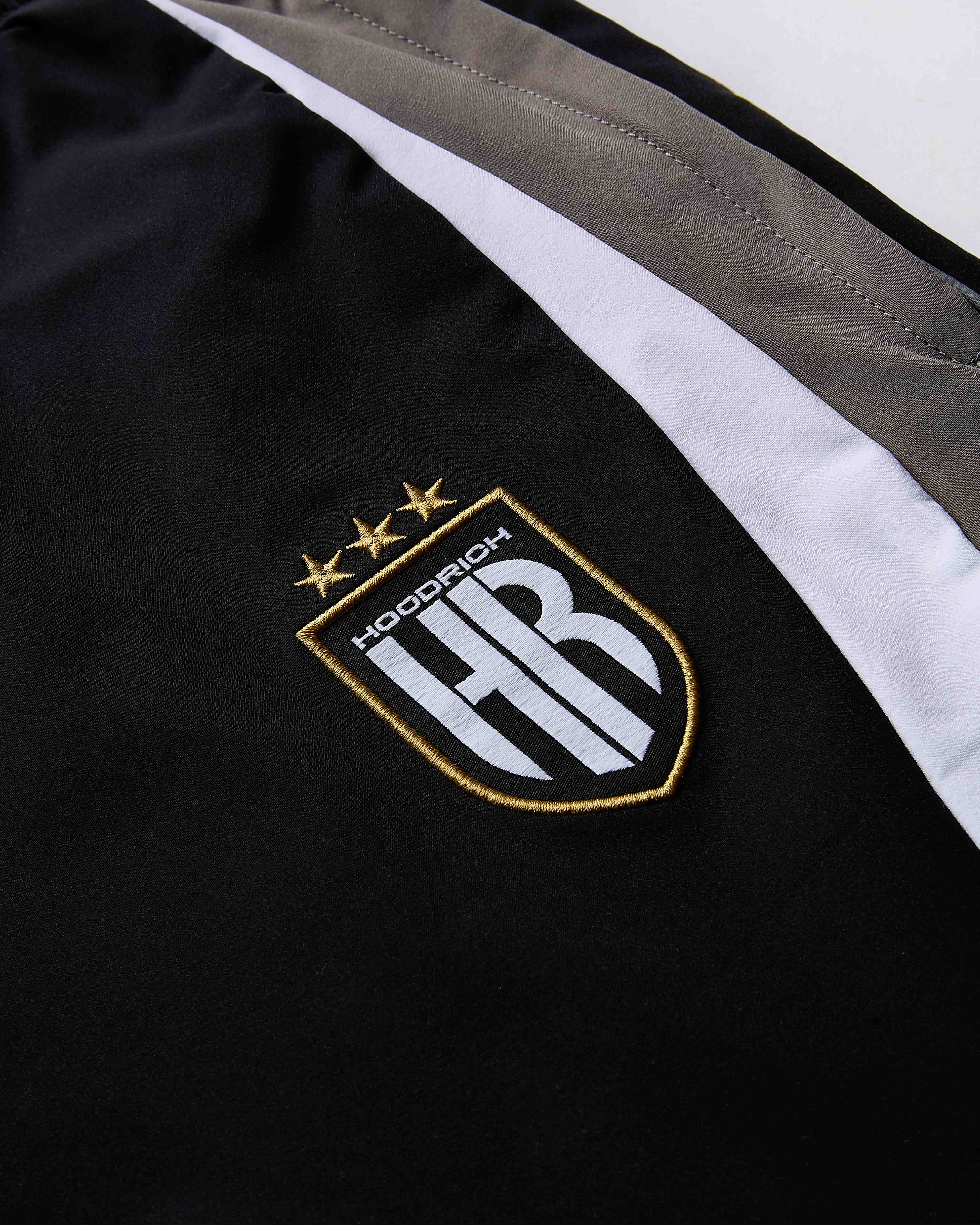 Close-up of a black jacket with a logo and text on a white background