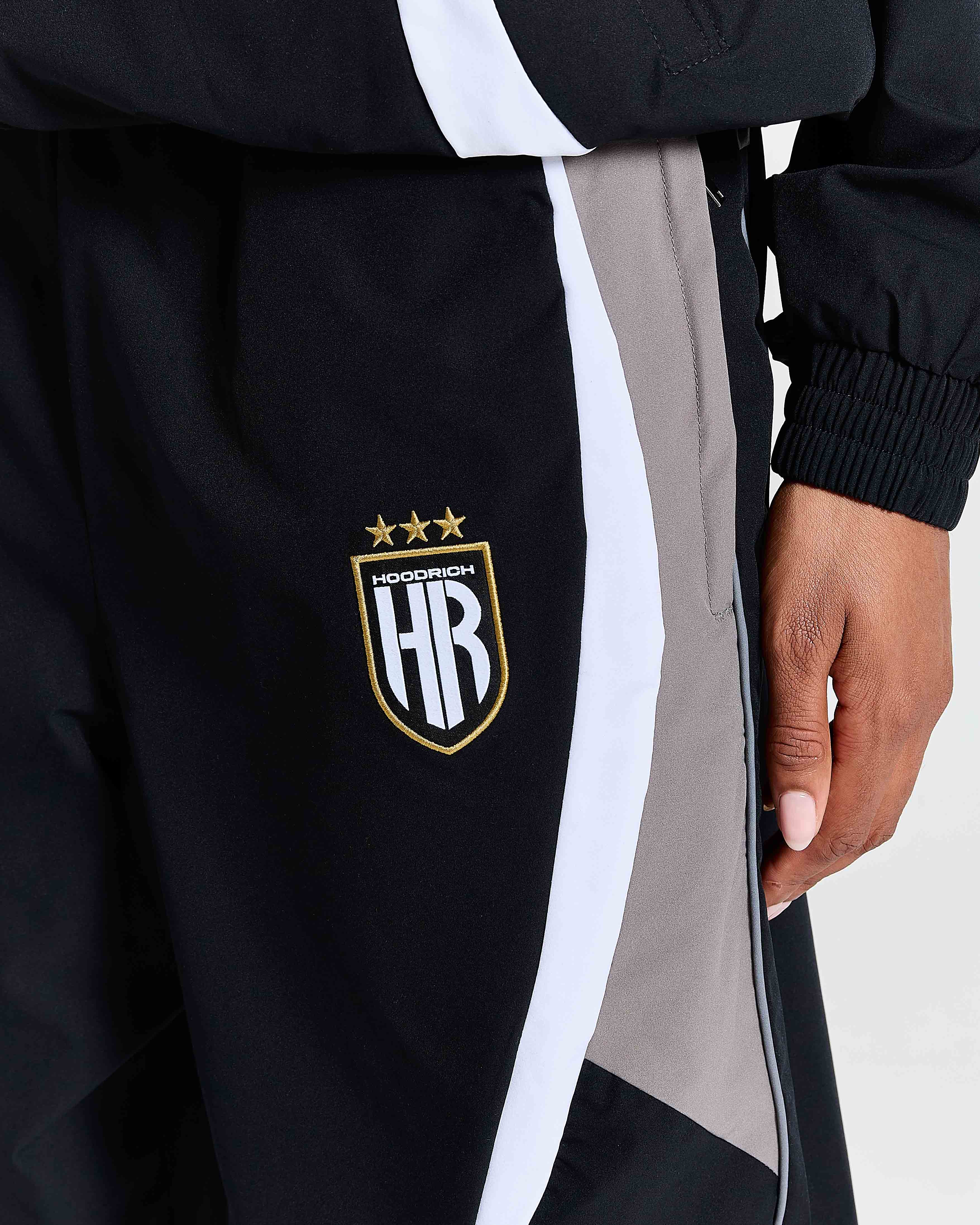 Black jacket with a logo on the chest, featuring stars and text, on a white background.