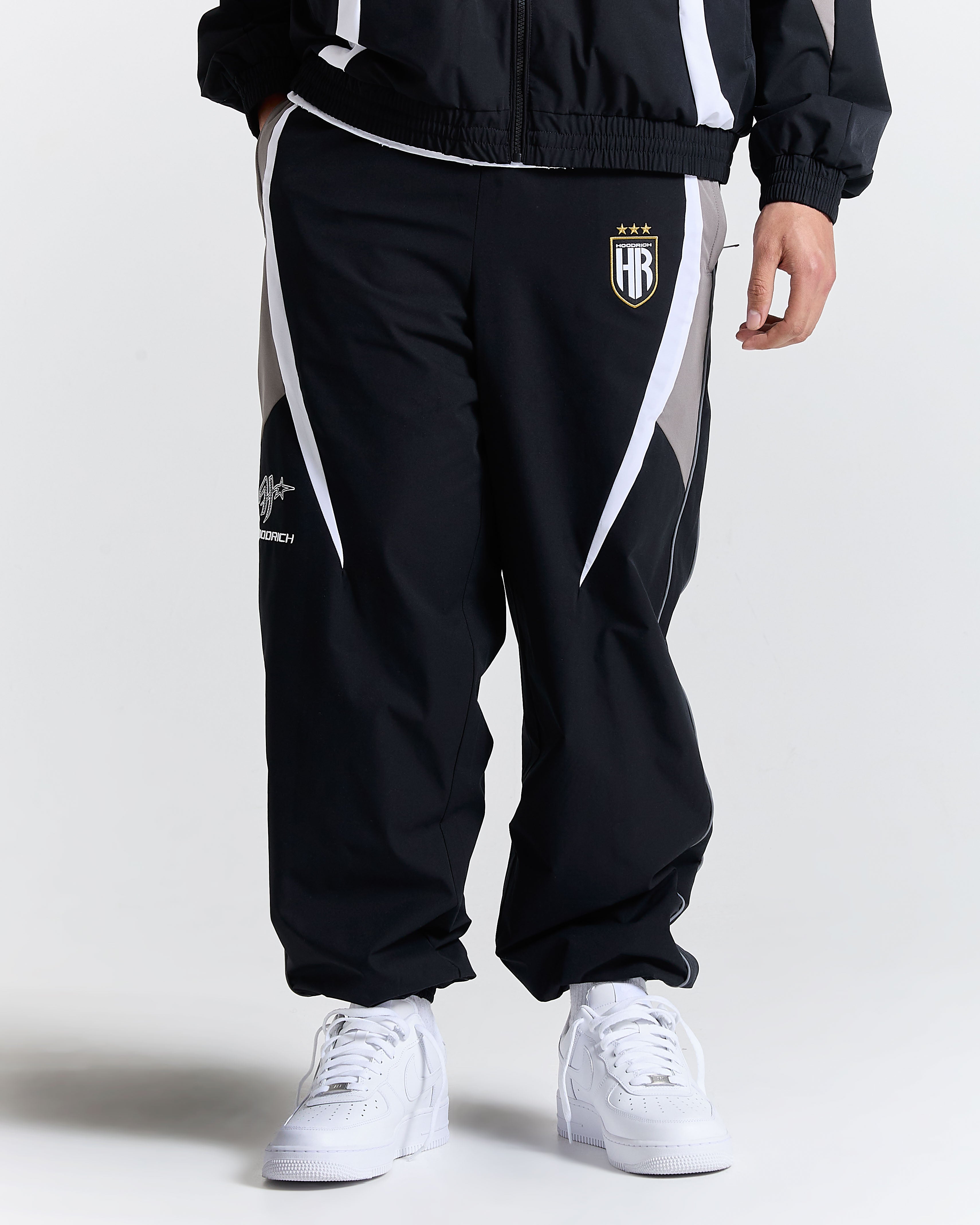 Black tracksuit with white accents and a logo on a white background