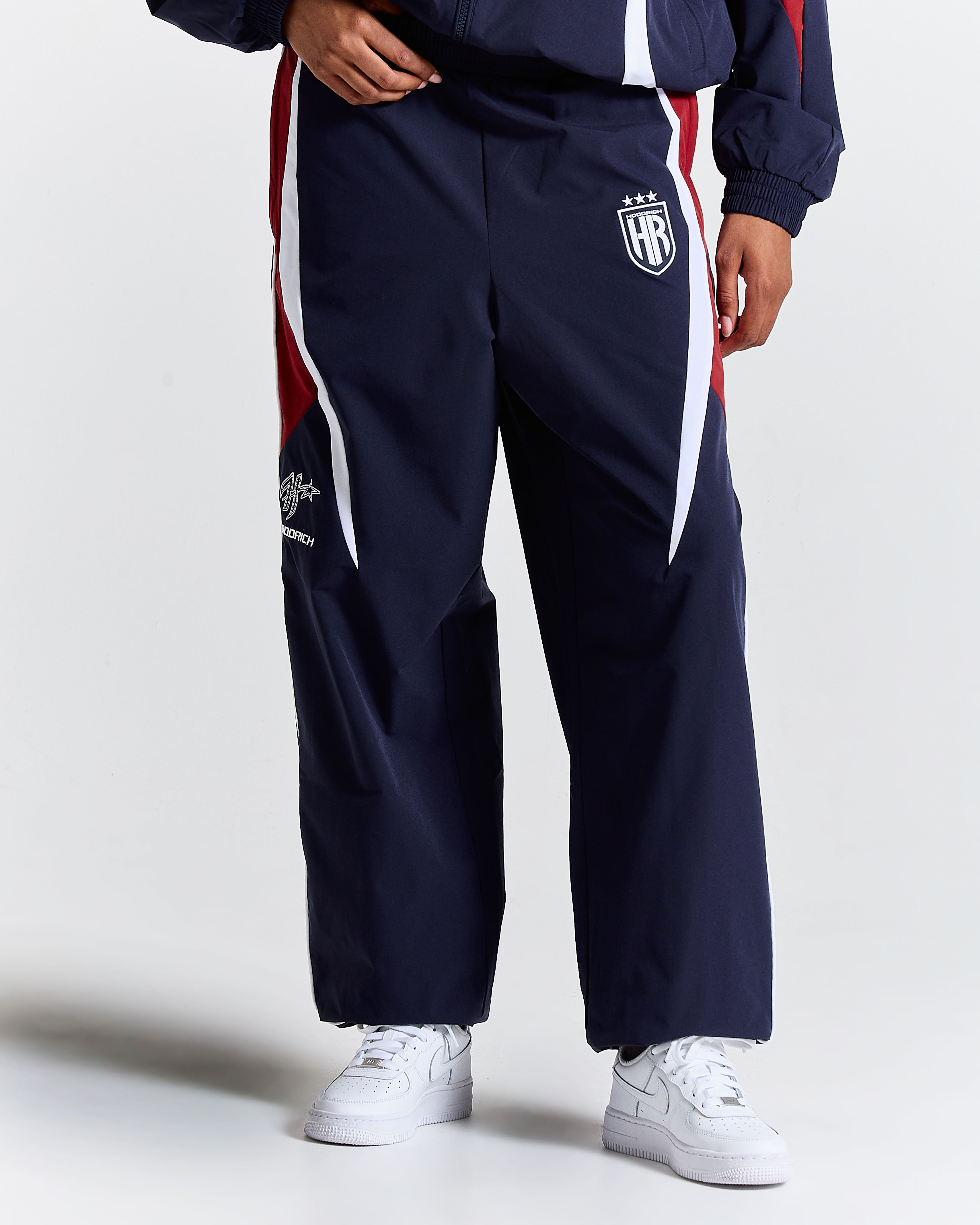 Navy tracksuit with white and red accents on a plain background