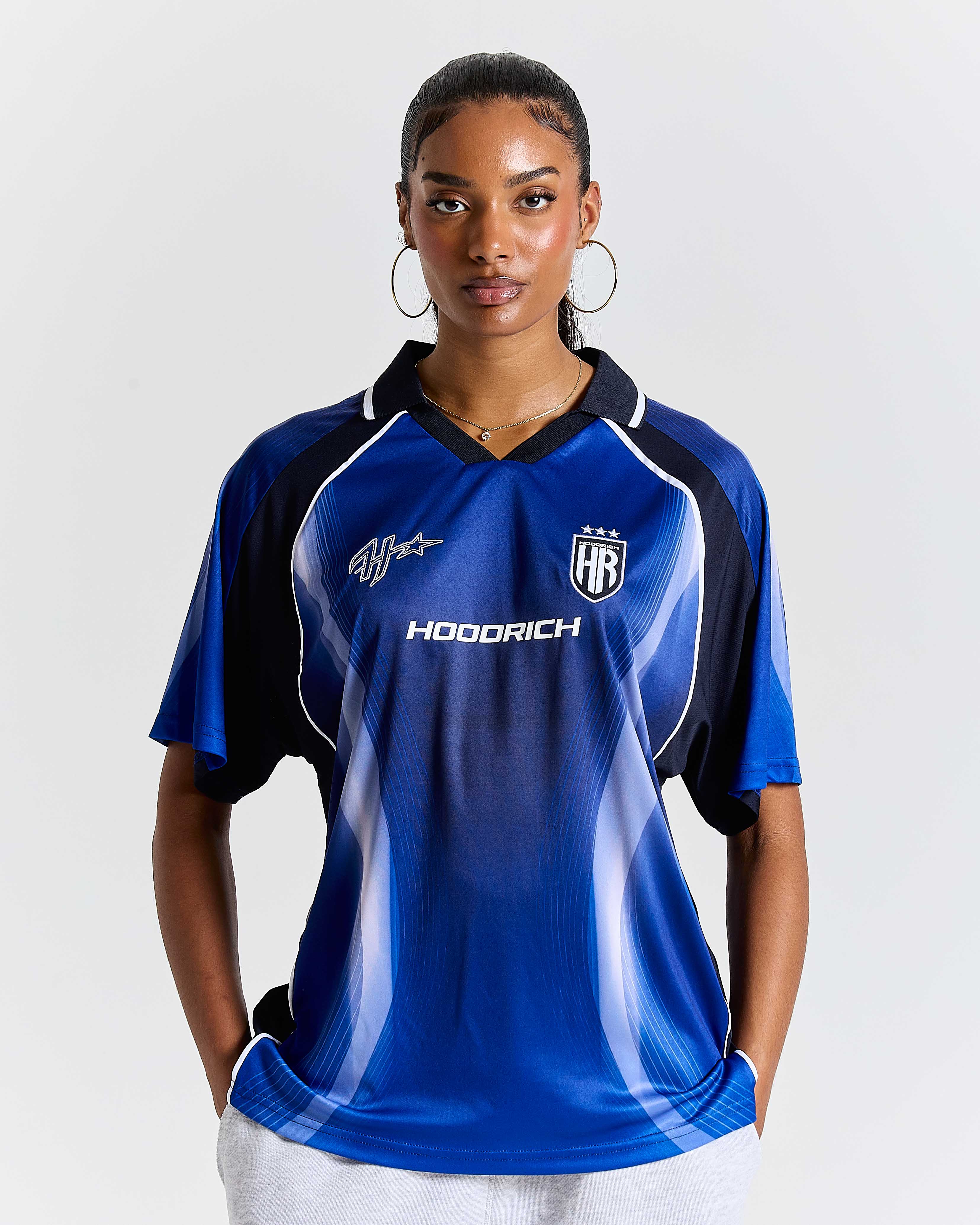 Person wearing a blue sports jersey with branding on a white background