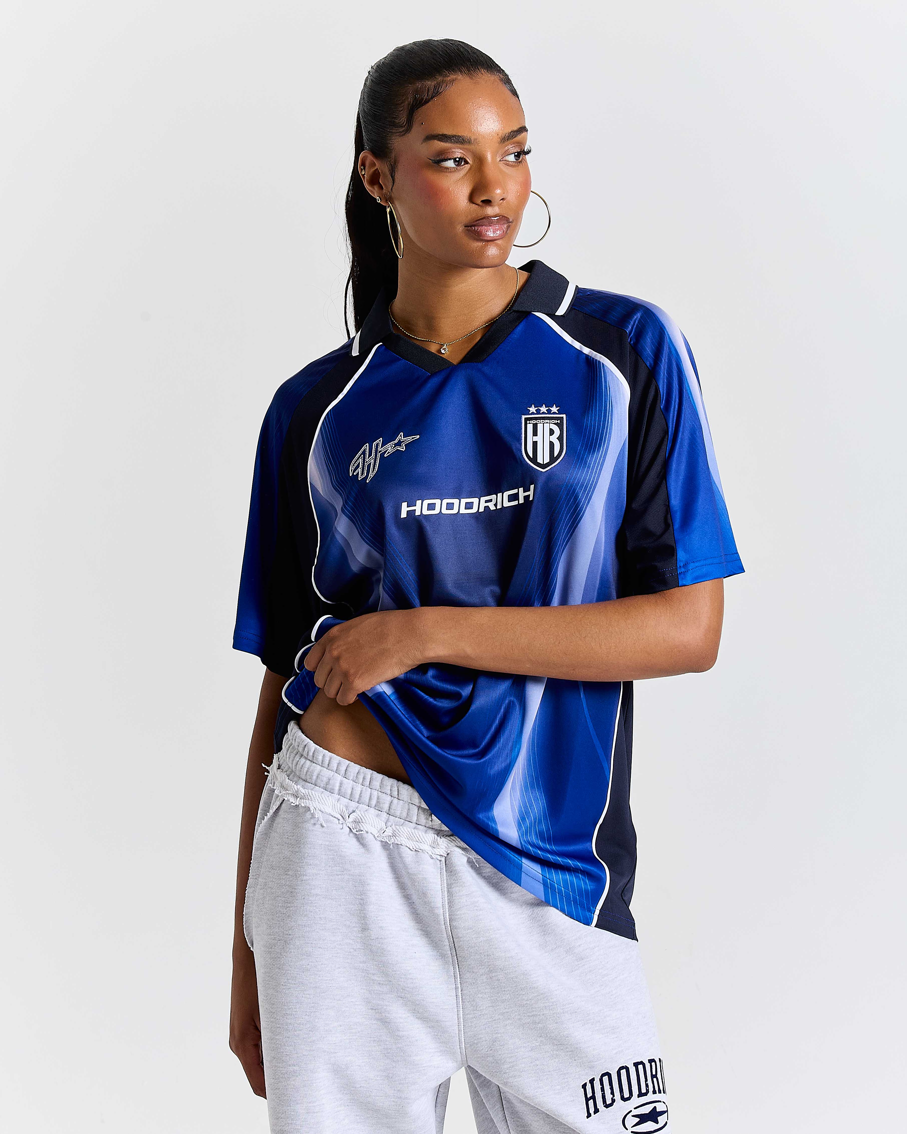 Person wearing a blue sports jersey with visible branding on a white background