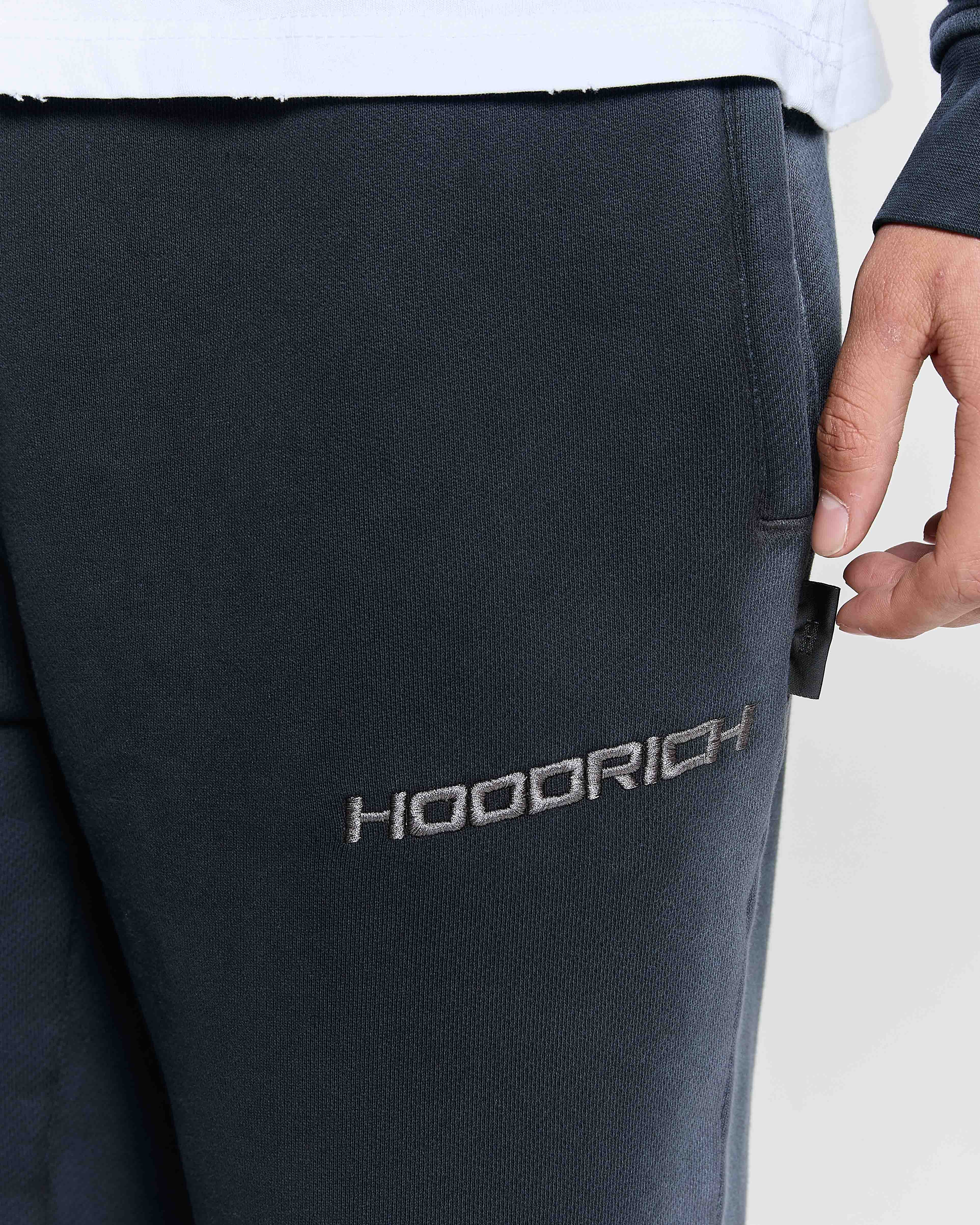 Black pants with 'HOODRICH' branding on a light gray background