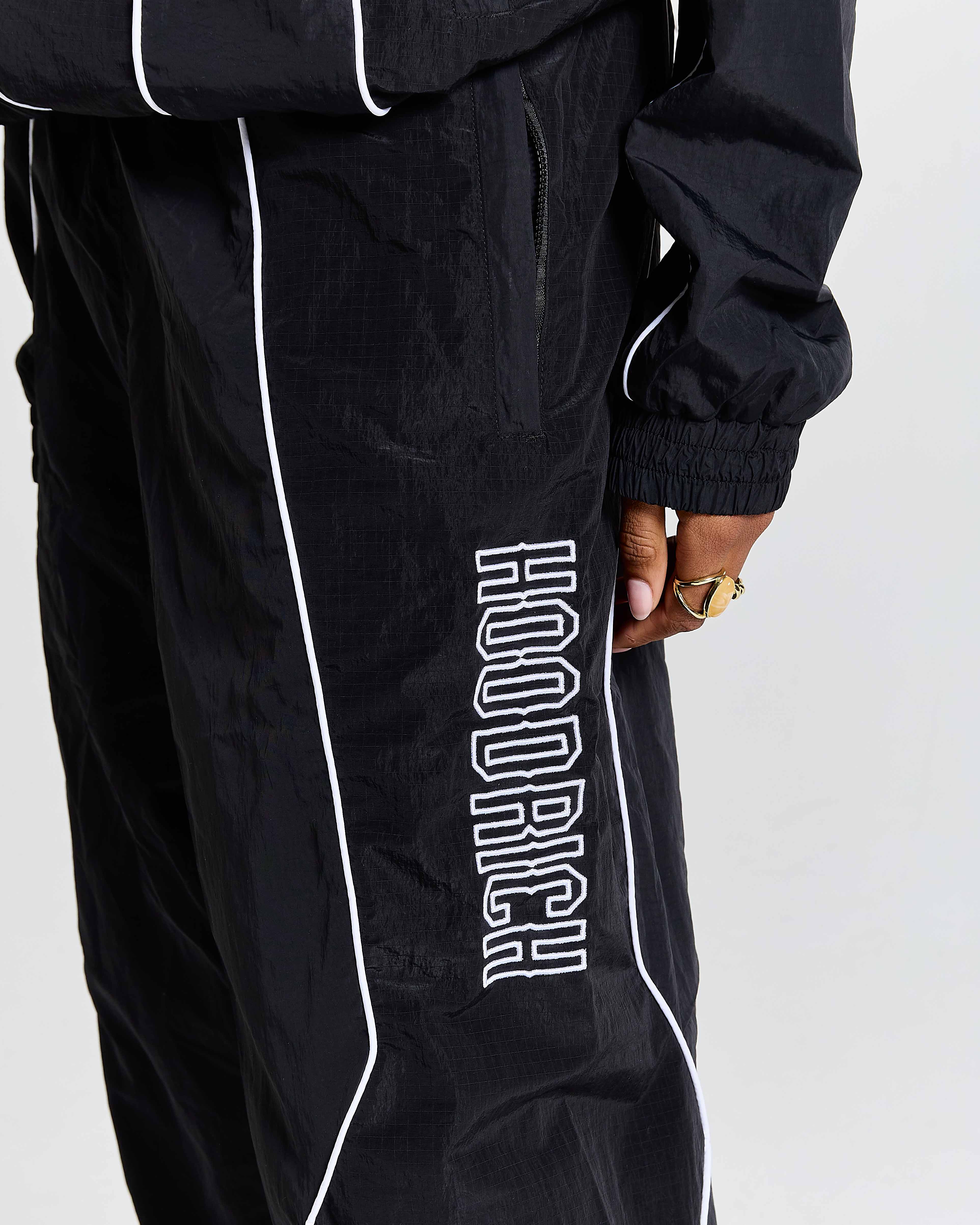 Black tracksuit with 'Hoodrich' branding on a white background