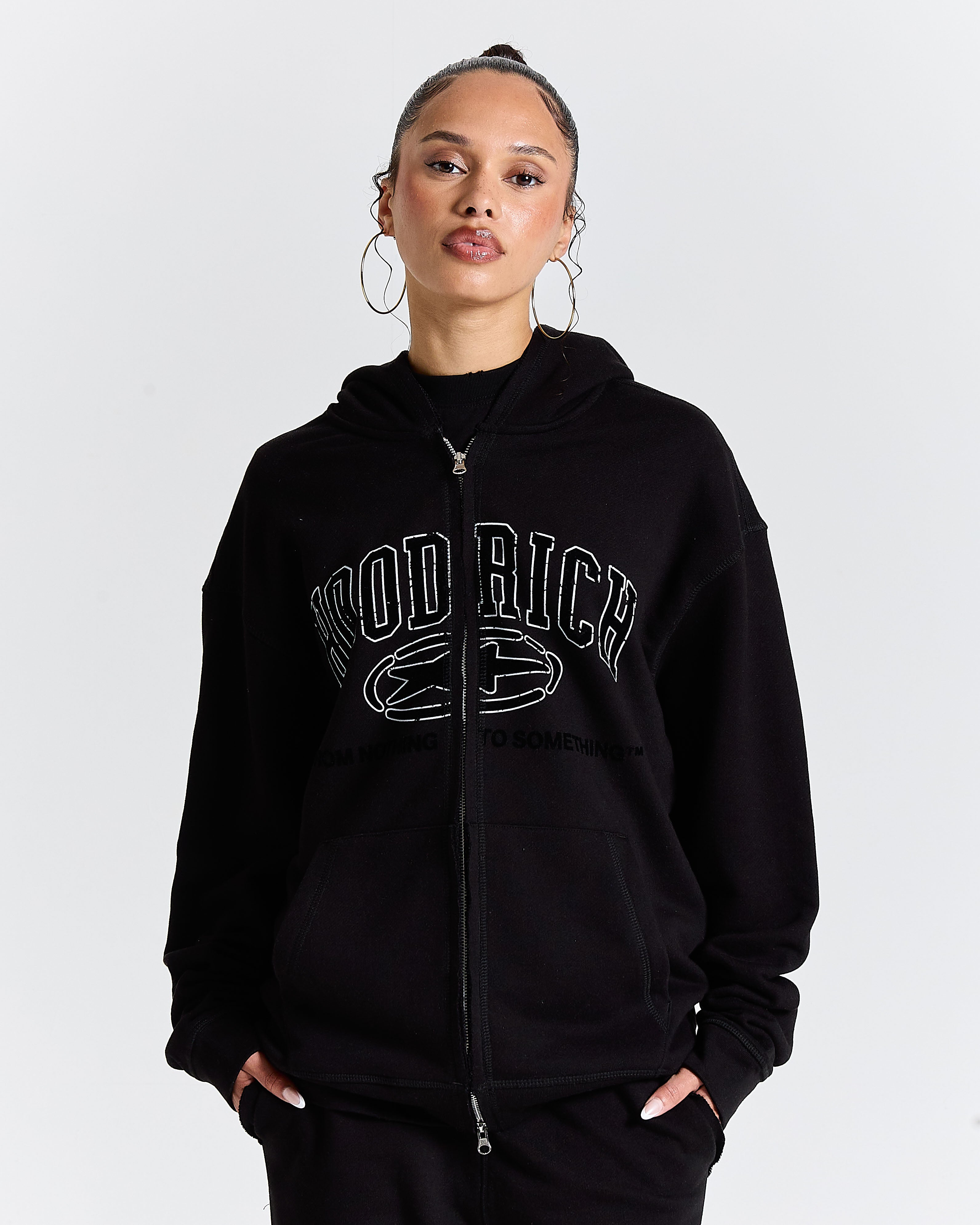 Person wearing a black hoodie with text on a white background