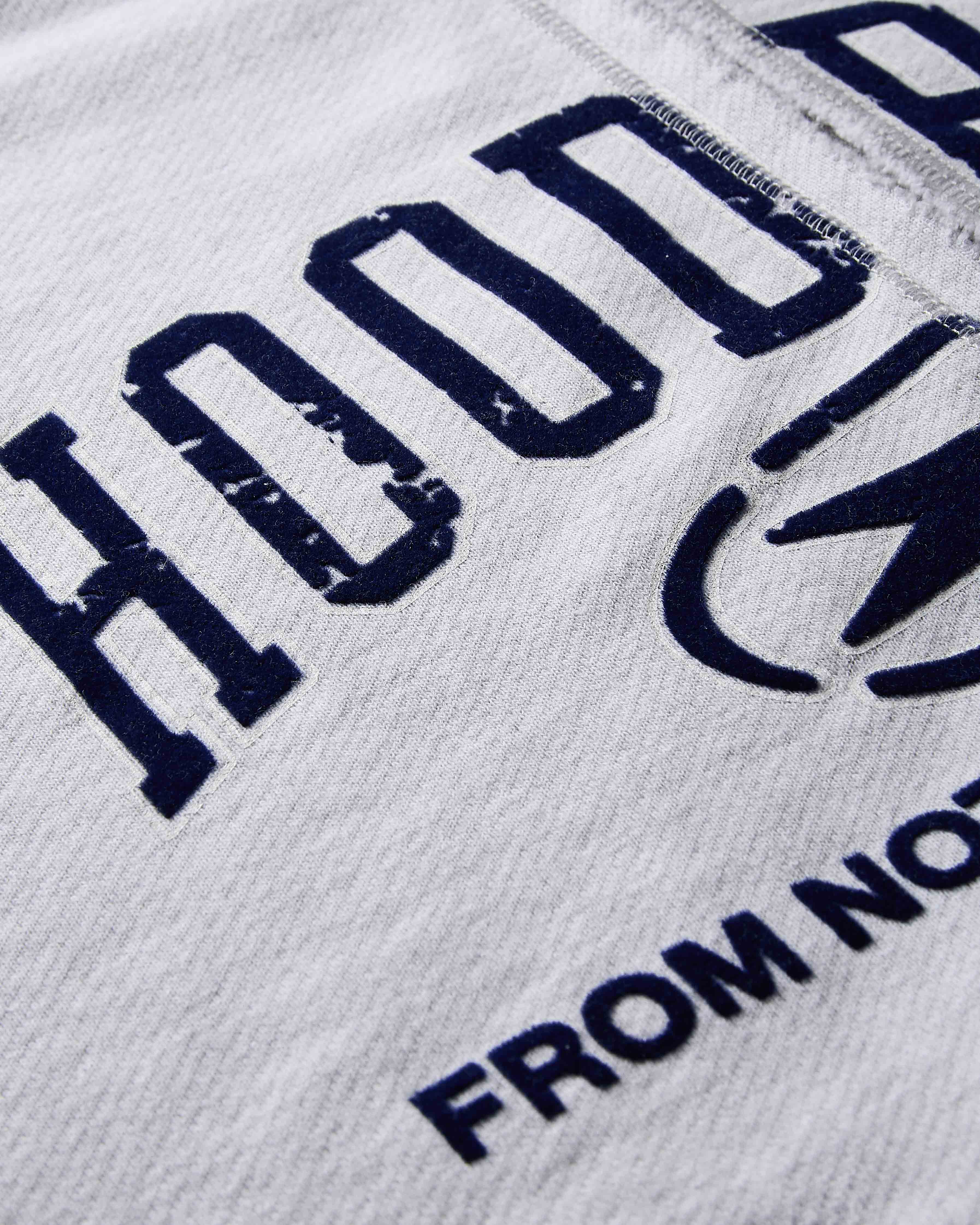 Close-up of a hoodie with text and logo on a gray background