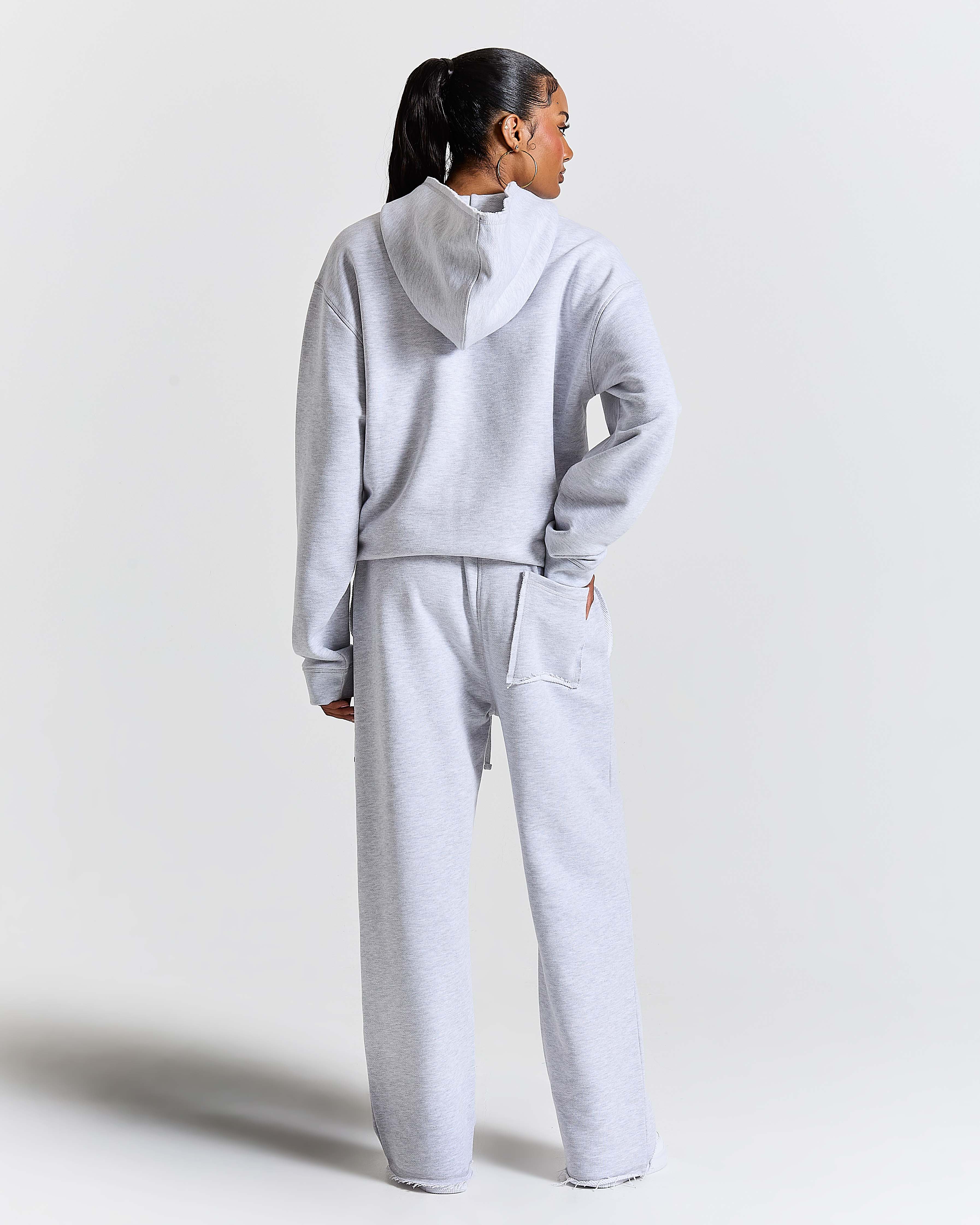 Person wearing a gray tracksuit on a white background