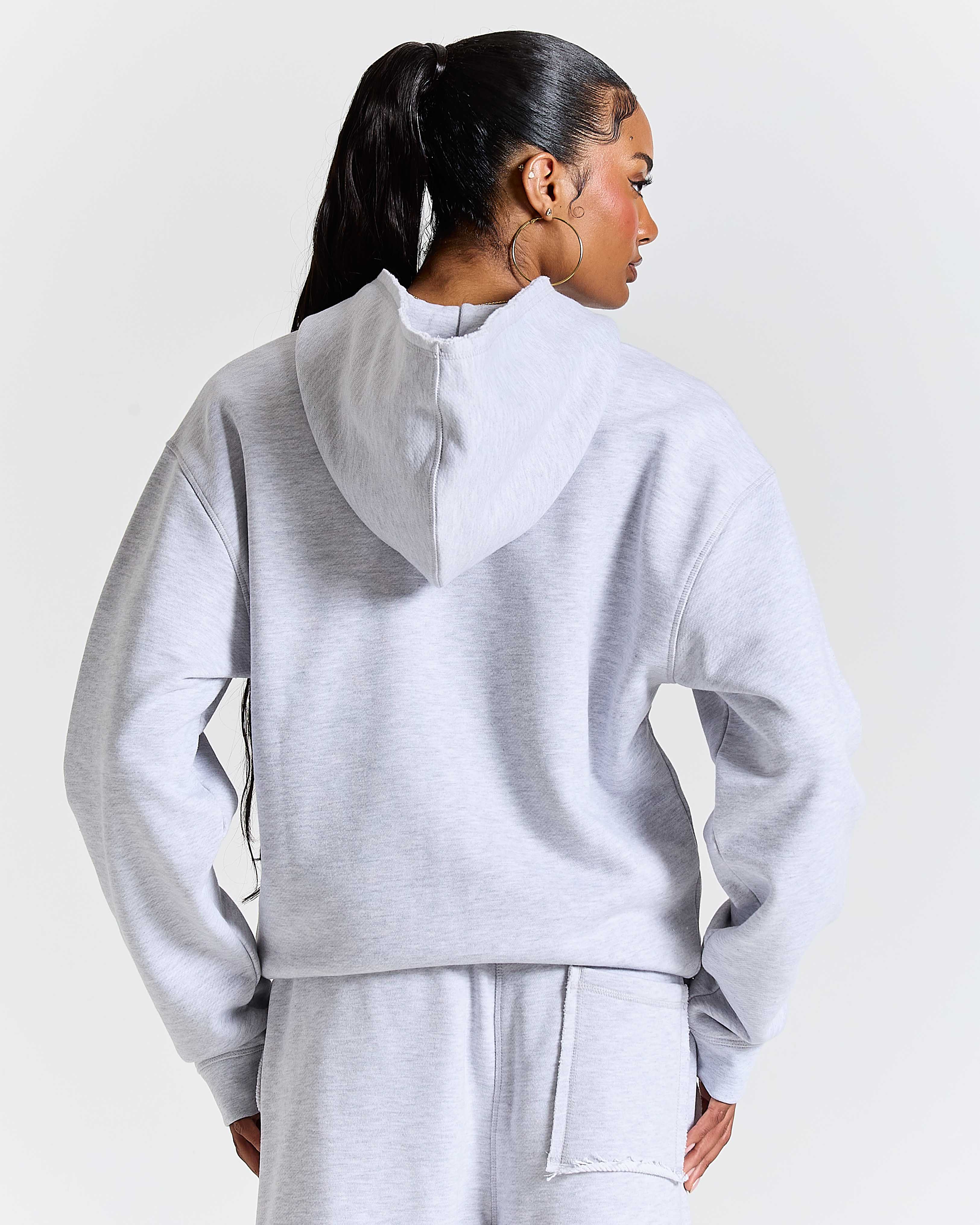Person wearing a gray tracksuit against a white background
