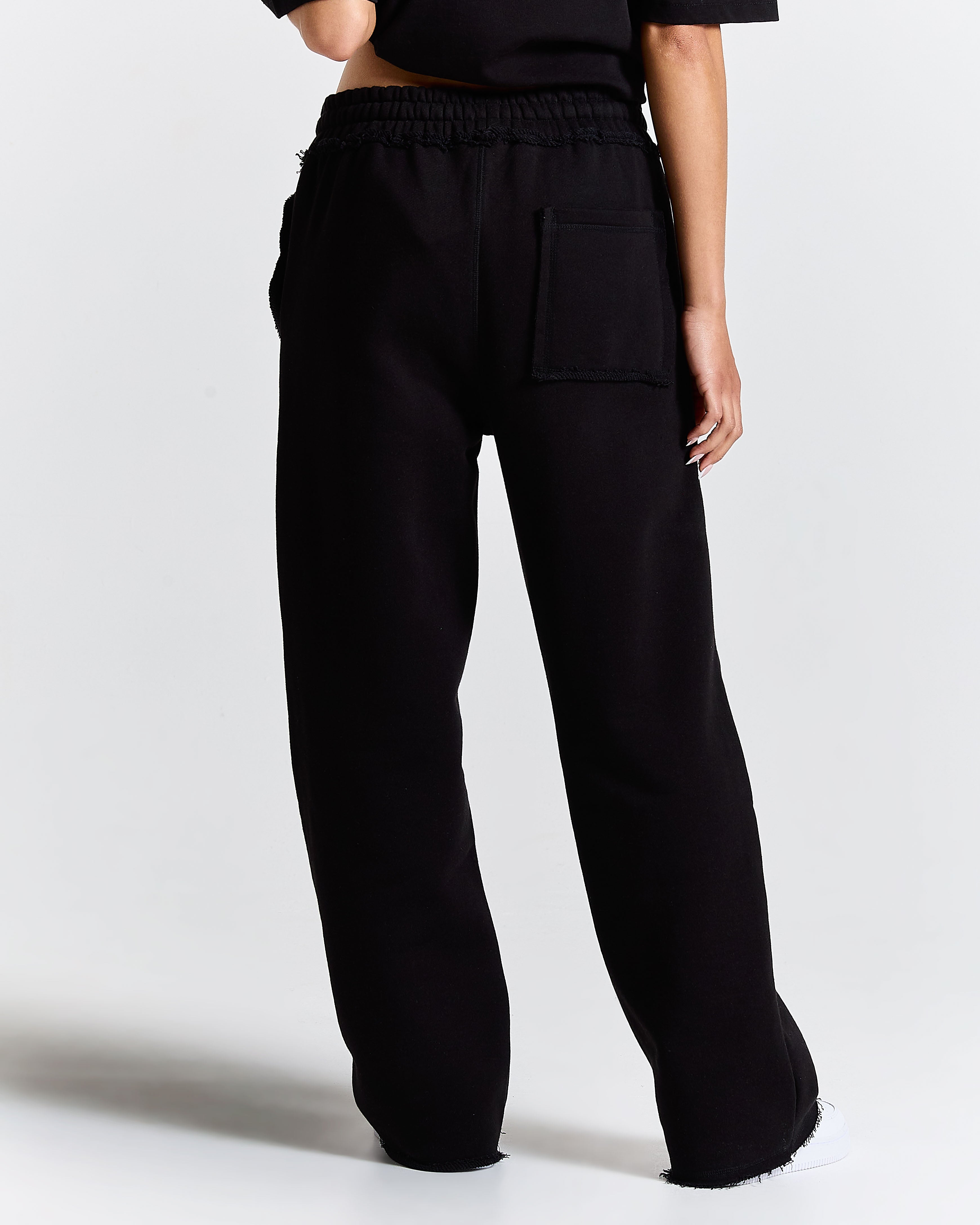 Black wide-leg pants worn by a person on a white background