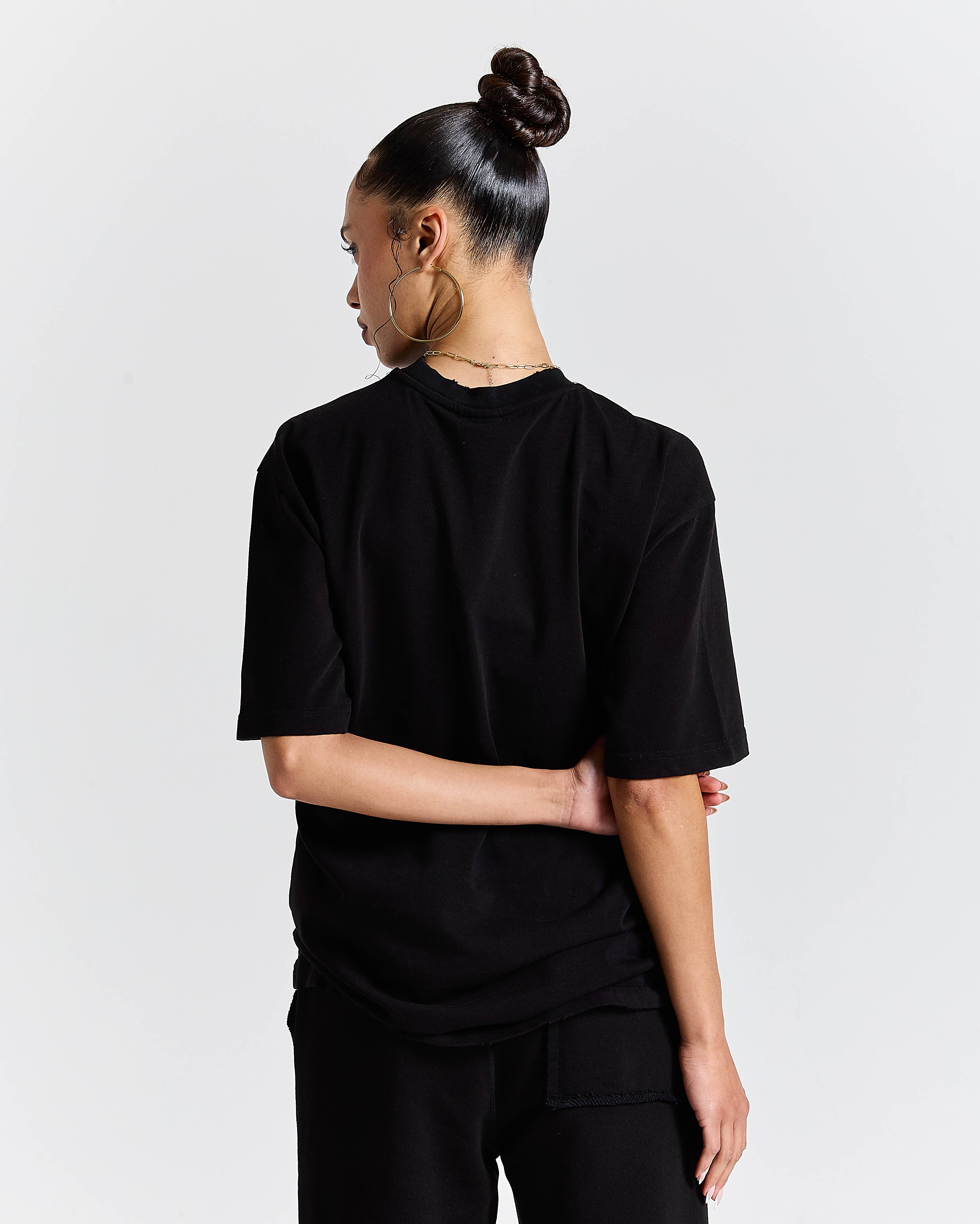 Person wearing a black outfit on a plain background