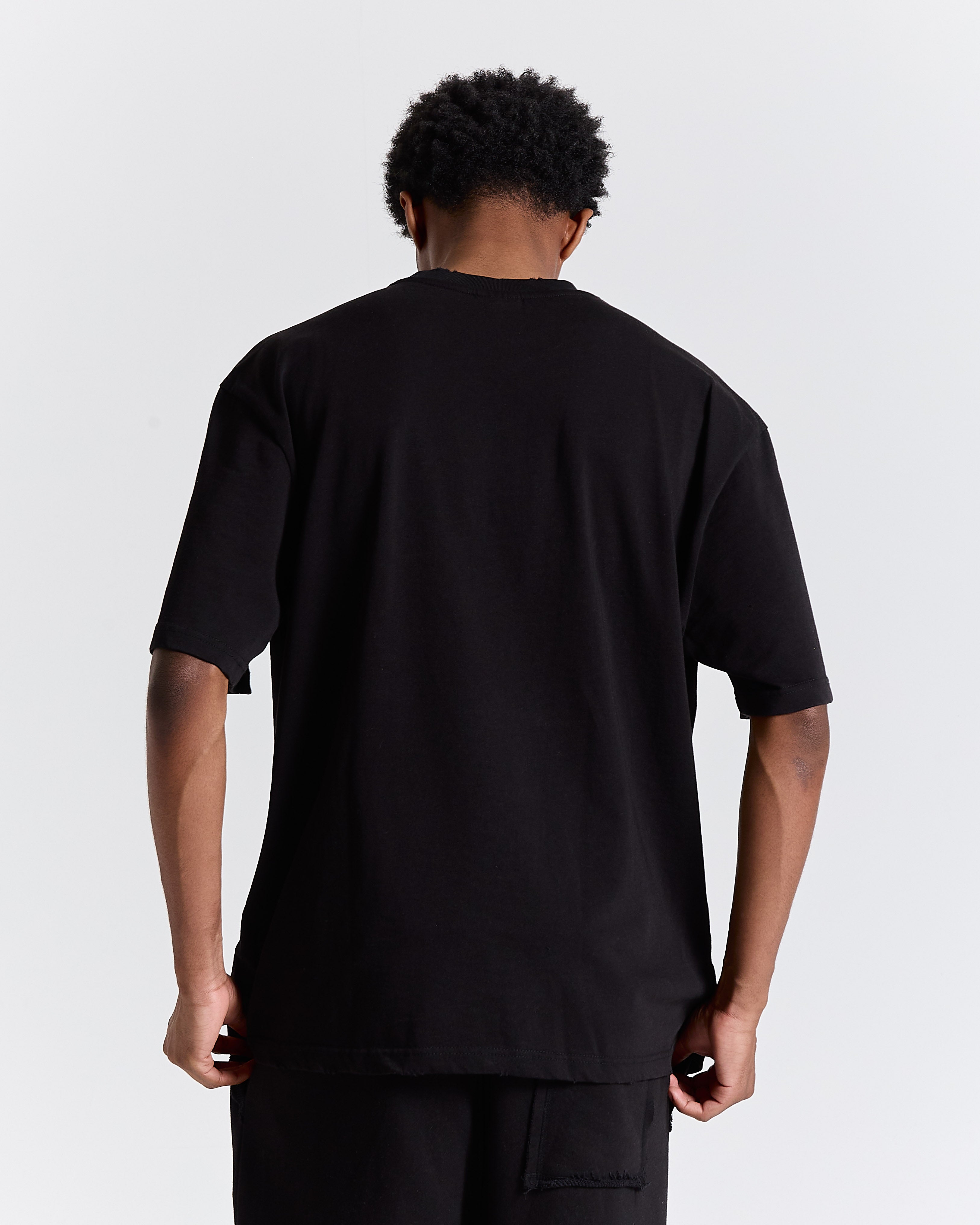 Person wearing a black t-shirt against a plain background