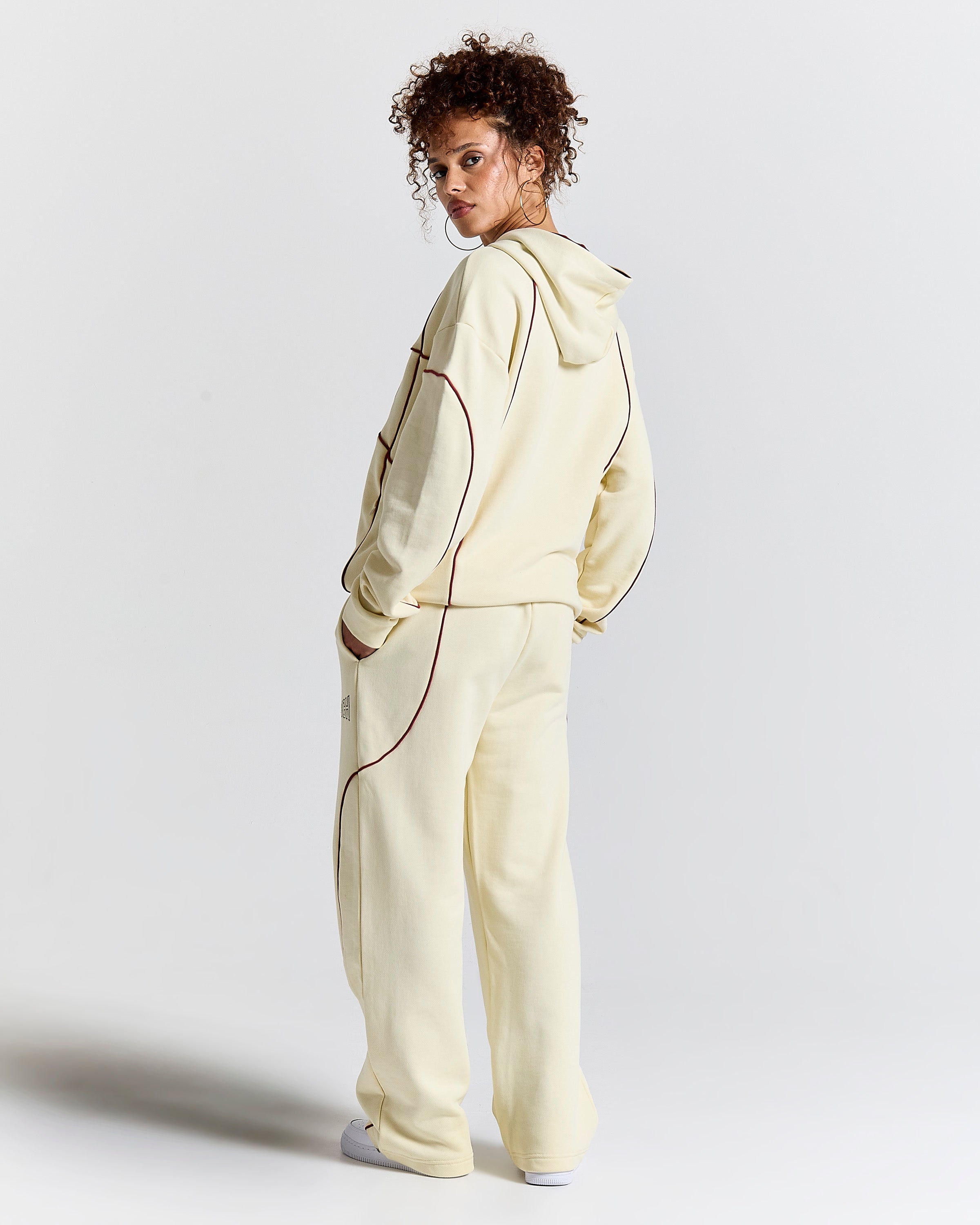 Person wearing a light-colored tracksuit on a plain background